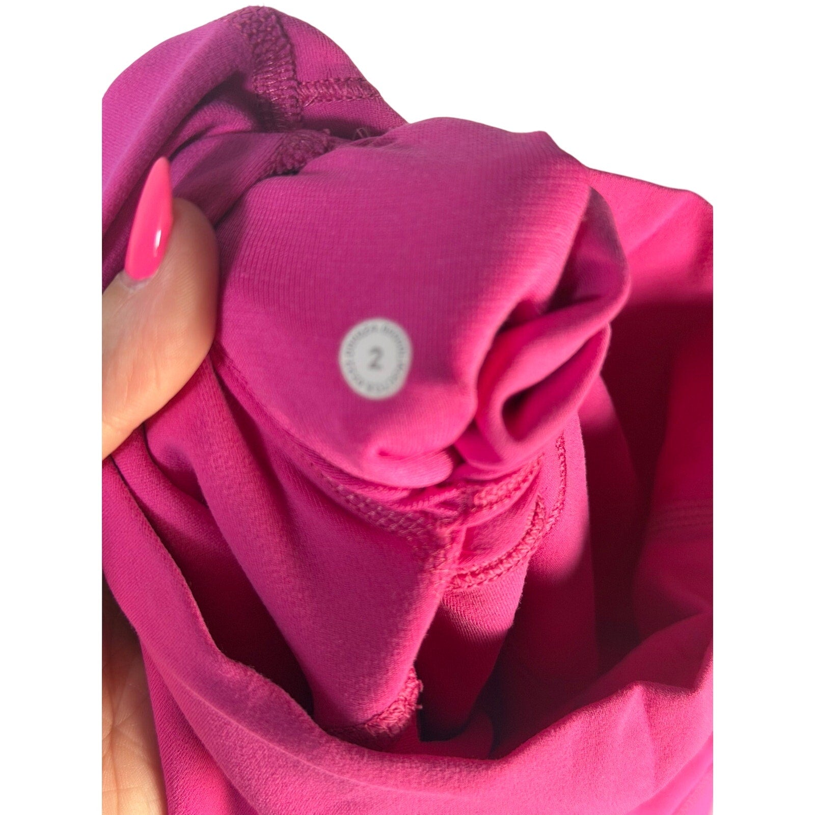Pink Lululemon Wunder Under high rise leggings for women, showing the fitted athletic pants with a high waistband.