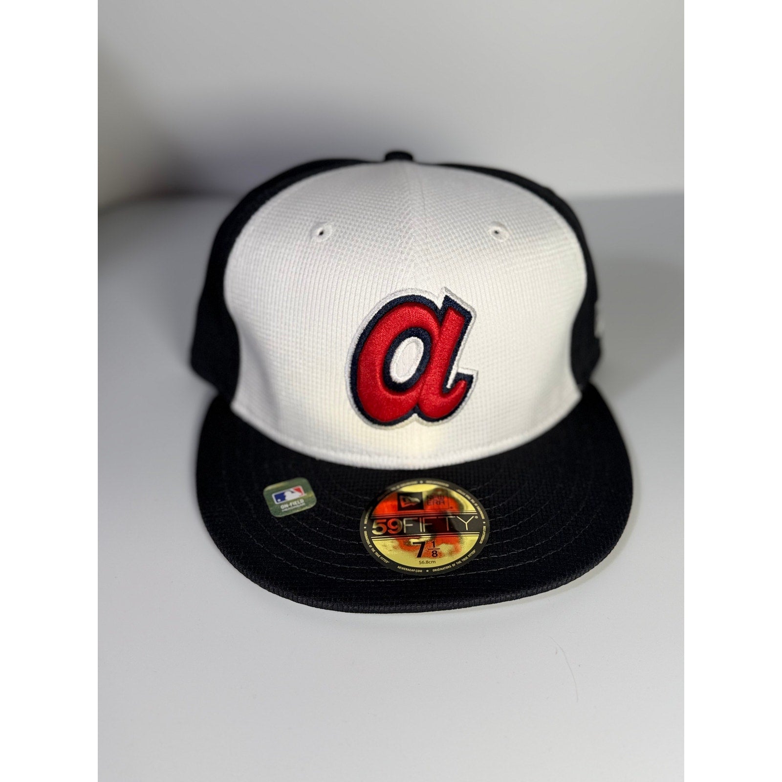 New Era Atlanta Braves 59FIFTY fitted cap in white and black, size 7 1/8, MLB team hat on a clean background.