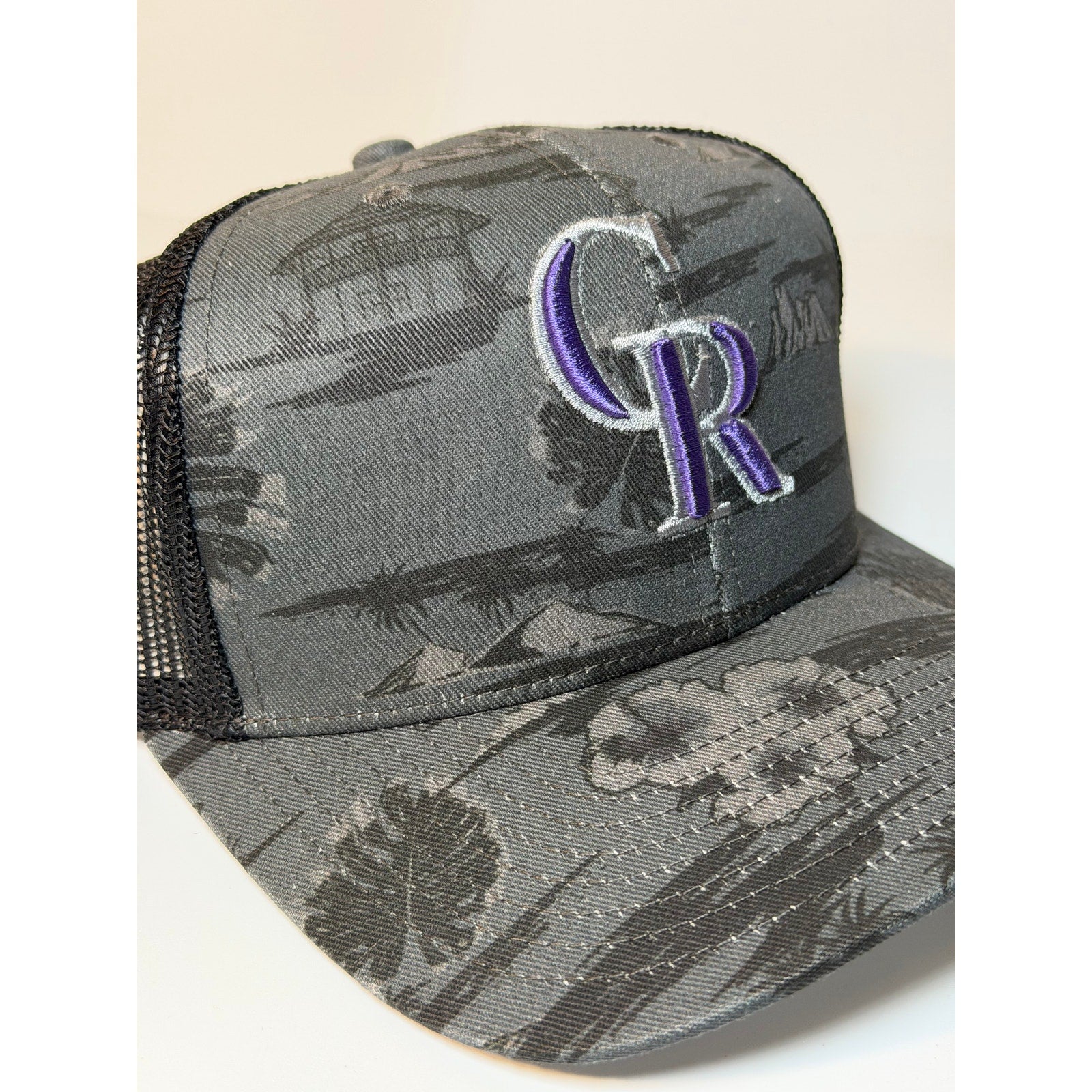 Gray and black 47 Brand Colorado Rockies trucker hat with floral snapback and adjustable fit.