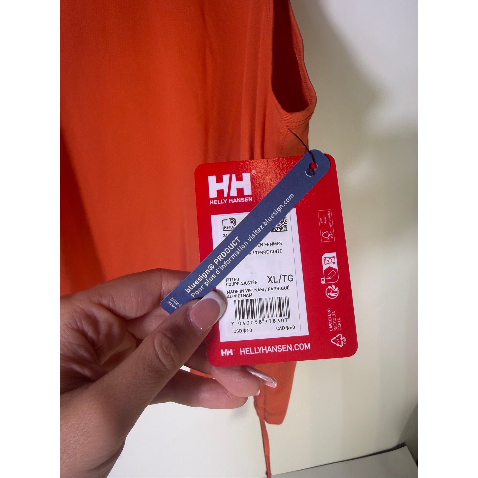 Helly Hansen women's orange active tank top with sleeveless design and drawstring hem, perfect for sports and workouts.