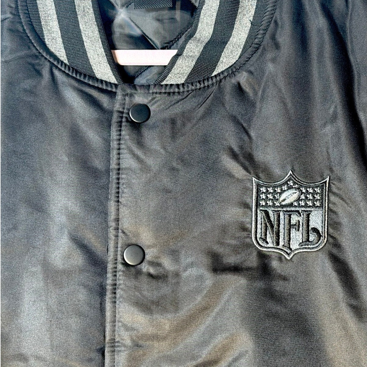 NFL men's varsity bomber jacket in black and gray with snap front, size large, featuring team logo and athletic style.