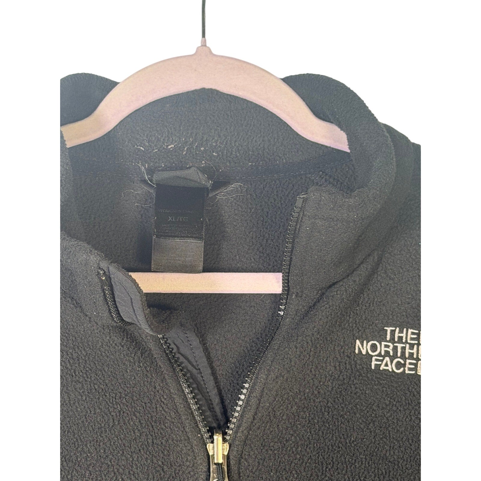 The North Face women's black full-zip fleece jacket with outdoor logo, showcasing the jacket's front view and zip closure.