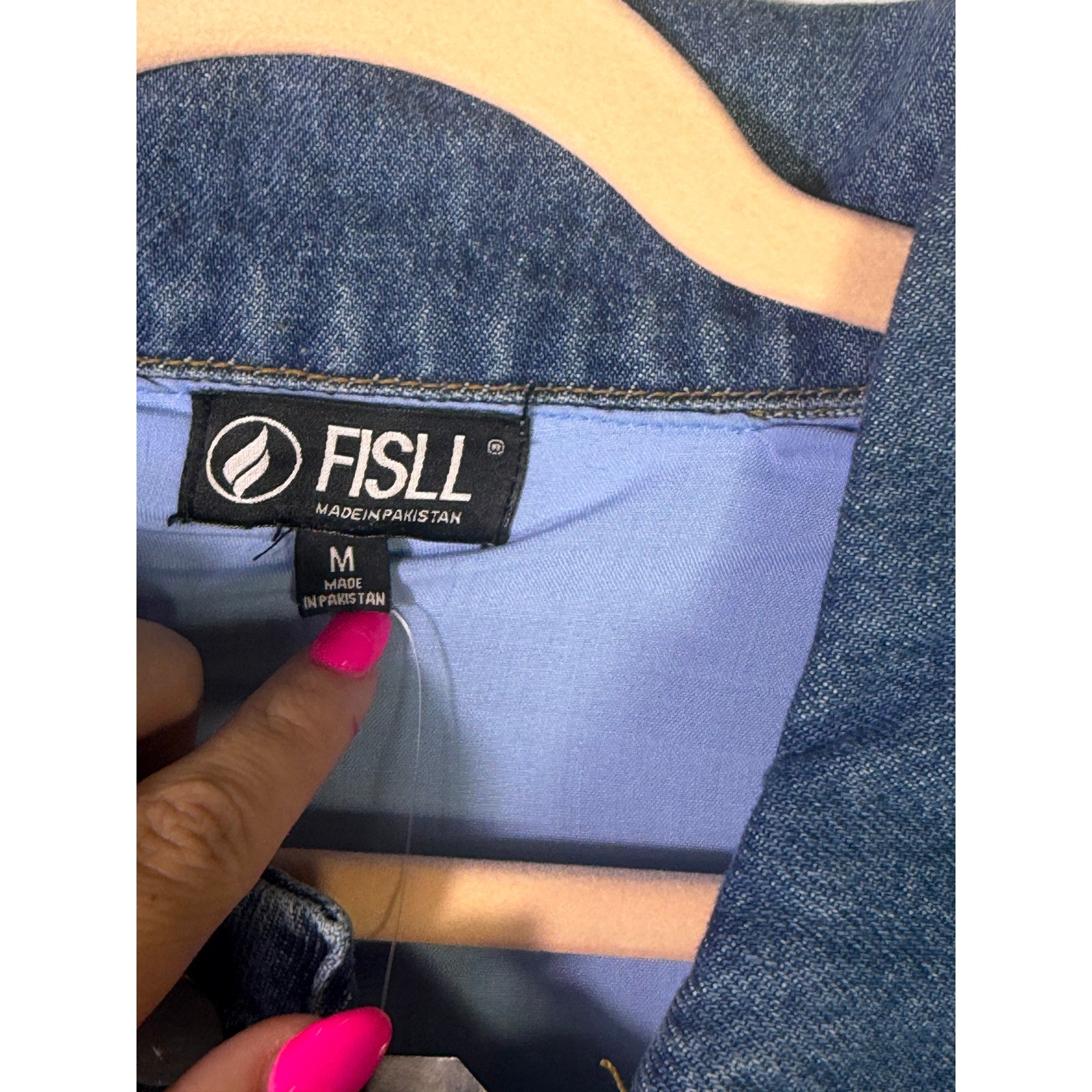 Unisex FISLL Las Vegas Aces Wilson denim jacket with #22 patch, medium size, displayed on a hanger.