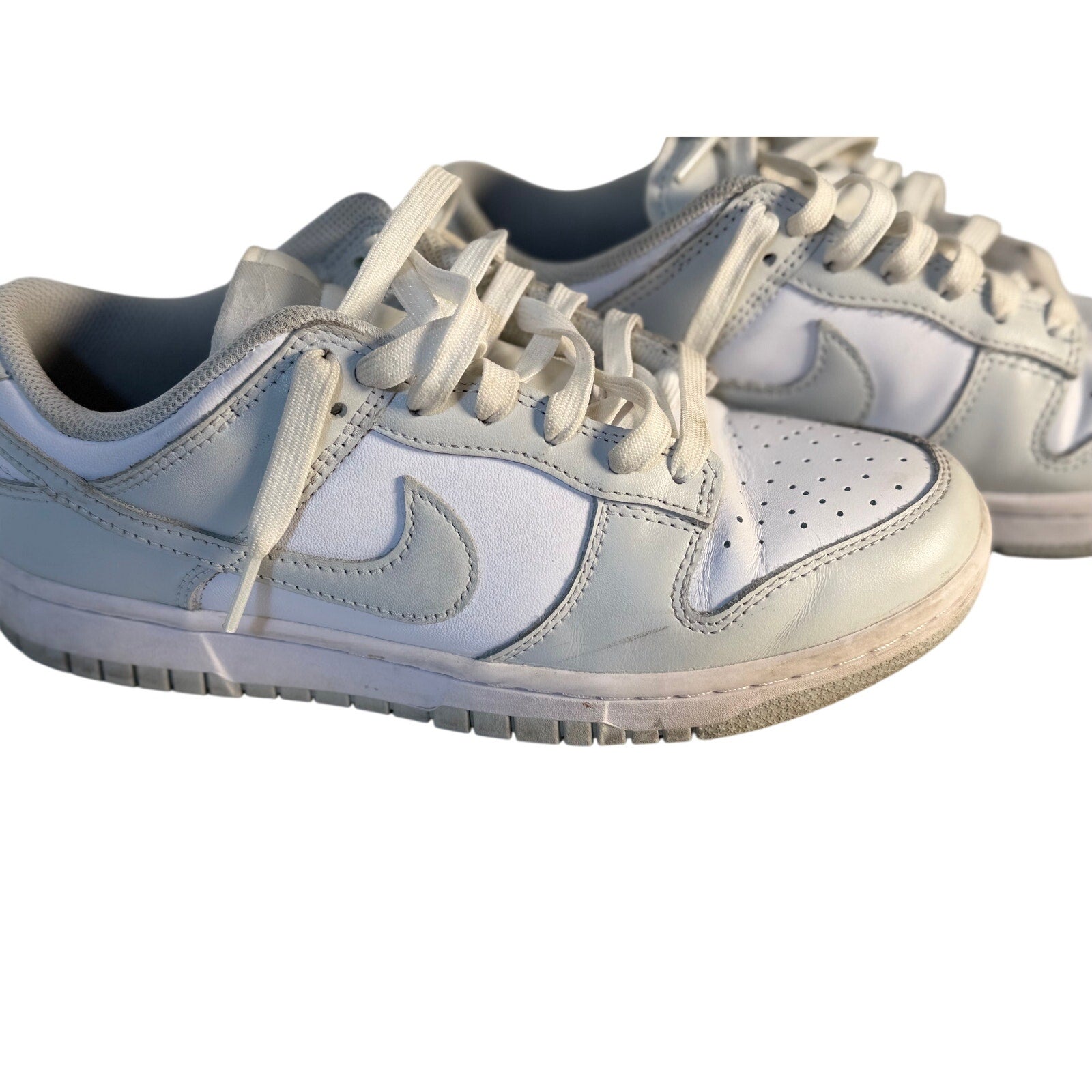 Nike Dunk Low Triple White sneakers for men, white leather casual shoes with a low-top design and Nike branding.