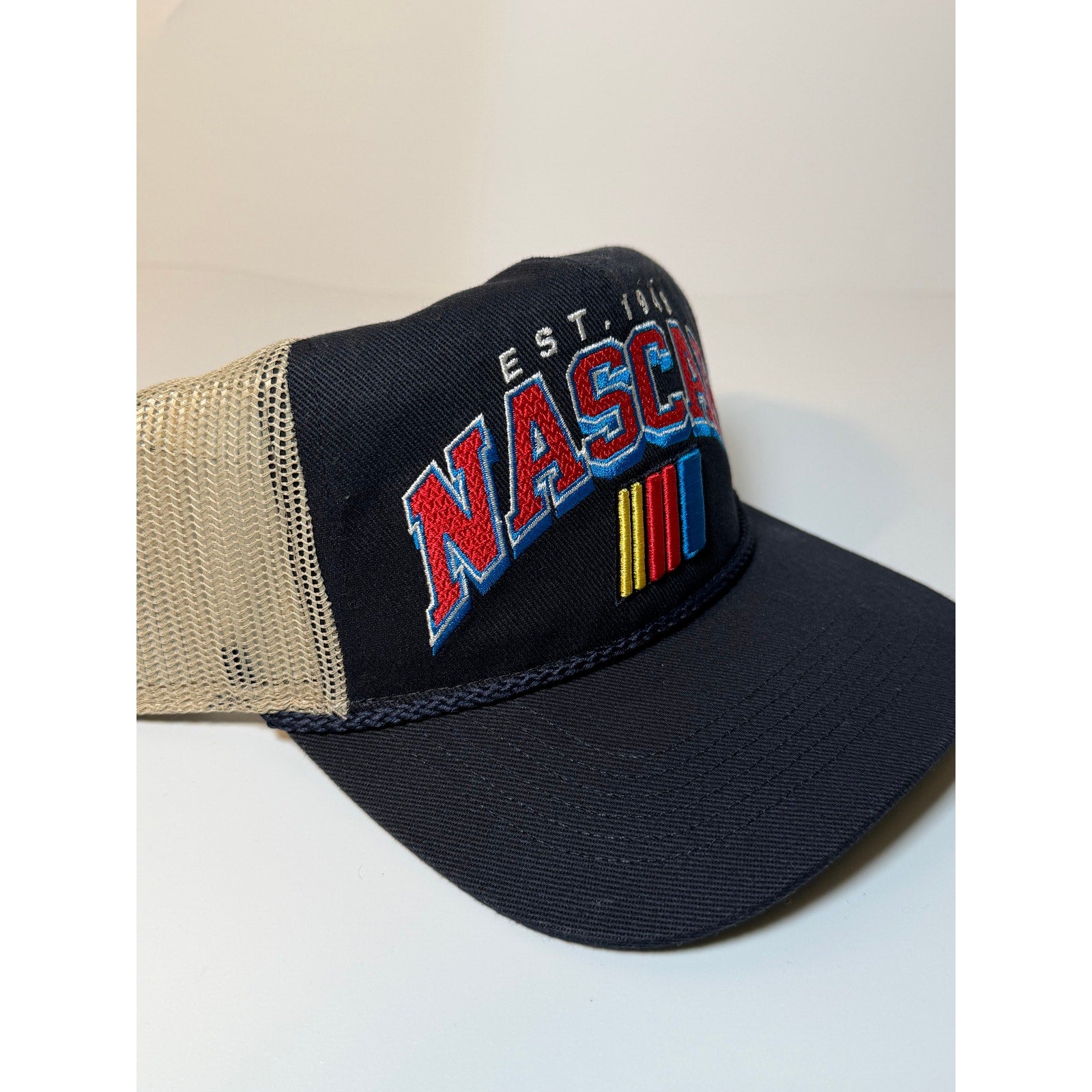 Navy and tan 47 Brand NASCAR trucker hat with embroidered logo, adjustable snapback, and classic trucker style.