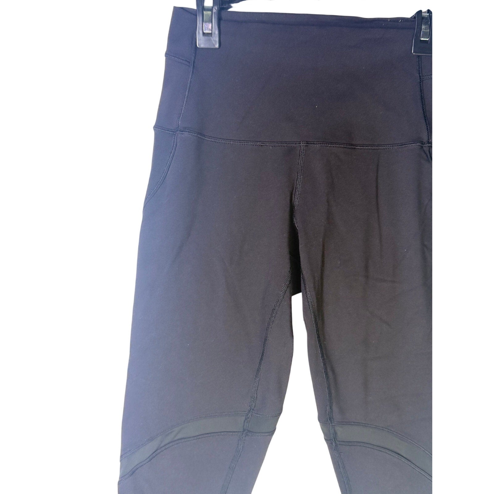 Black Lululemon women's high-rise paneled cropped leggings, size 6, showing the fitted waistband and stylish panel details.