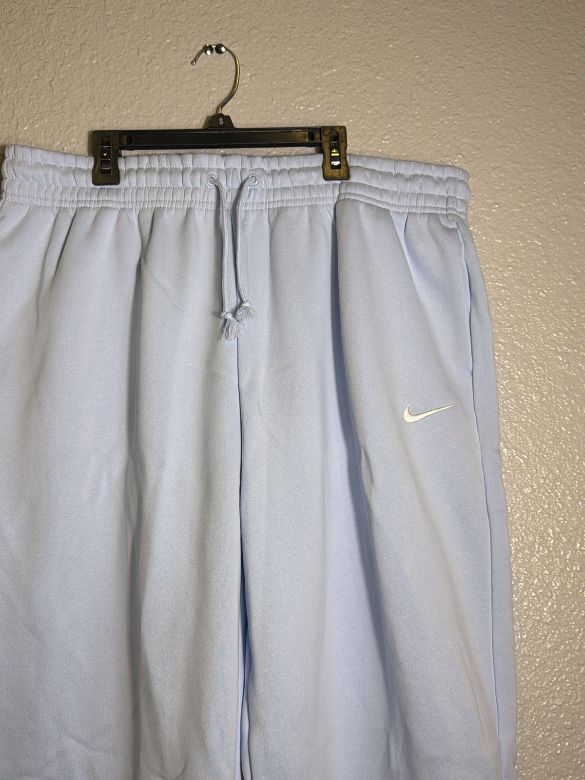 Light blue Nike Sportswear Phoenix fleece high-waisted oversized women's sweatpants, XL size, laid flat showing relaxed fit and soft fabric
