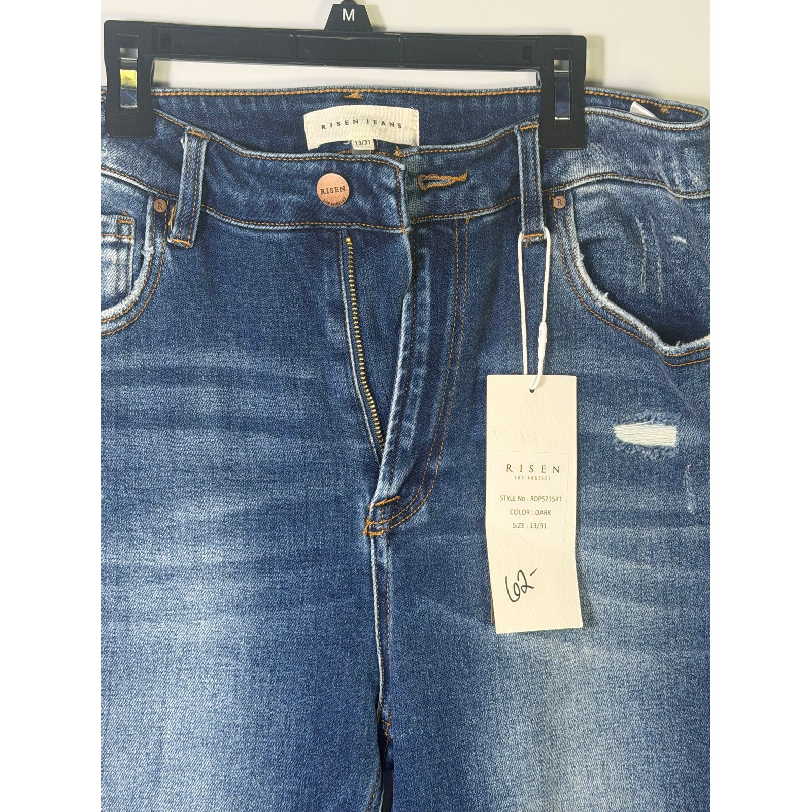 Dark wash Risen Jeans women's size 13/31 with distressed flare style, showcasing a fitted waist and stylish leg opening.