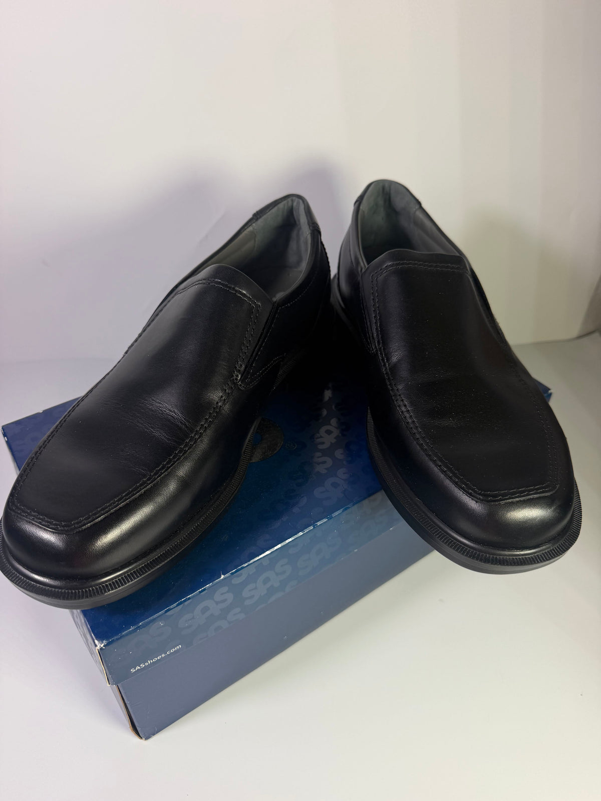 SAS men's black leather slip-on loafers size 11.5 W, new in box, showcasing the sleek, comfortable flat footwear design.