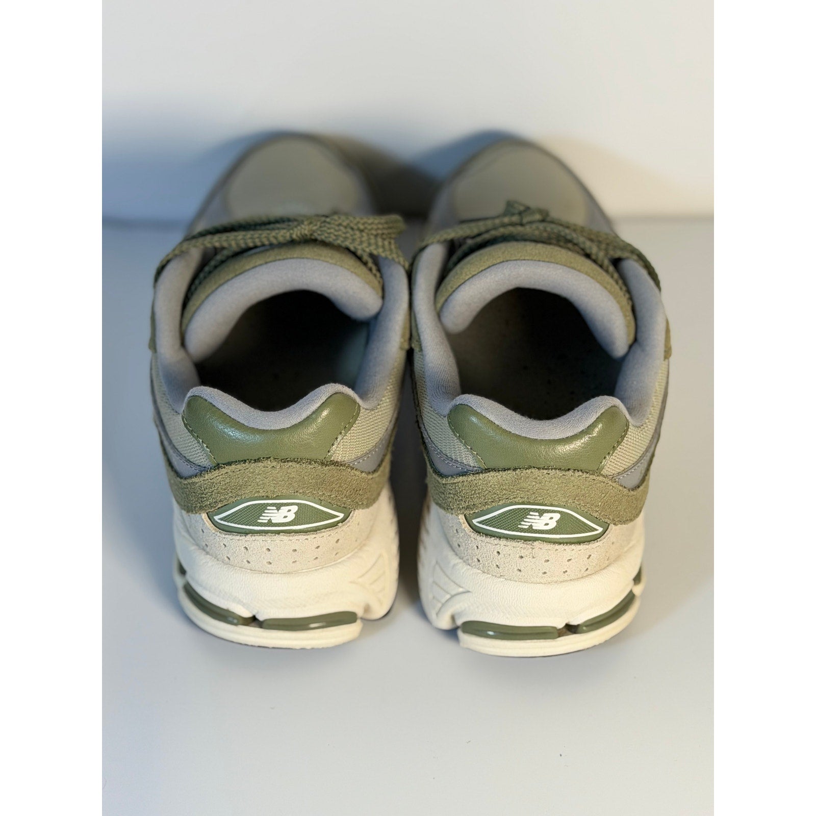 Pre-owned New Balance 2002R athletic running sneakers in olive and gray for youth size 5.5, showing side view of shoes.