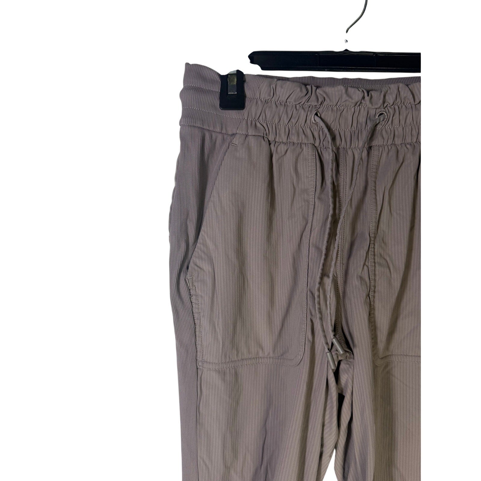 Lululemon women's taupe gray high-rise ruched tapered pants, size 4, preowned, shown laid flat with waistband and tapered leg details.