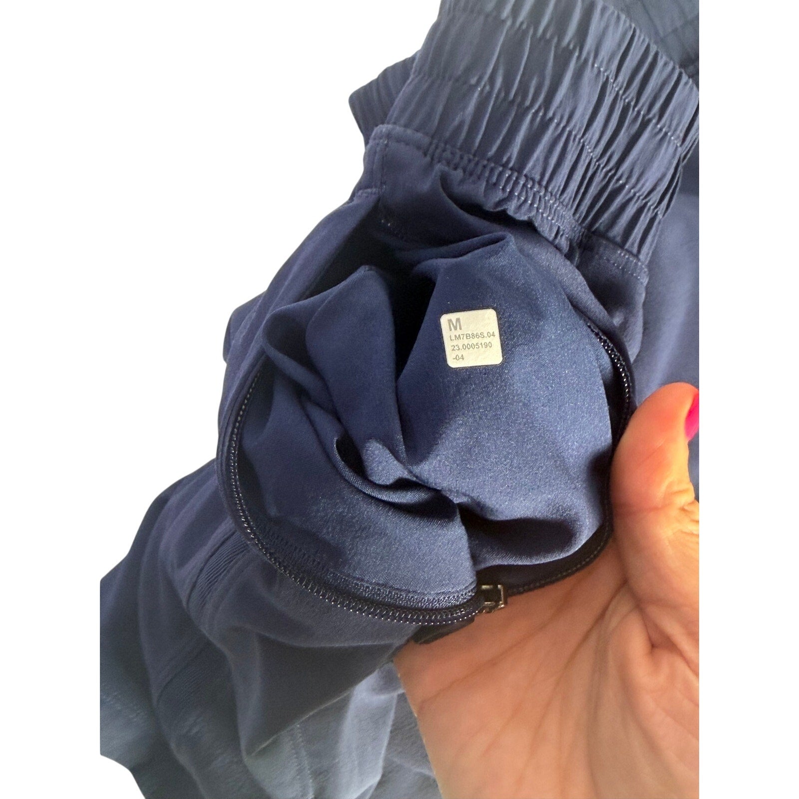 Lululemon men's navy blue athletic running shorts, size M, made of lightweight fabric with elastic waistband and side pockets.