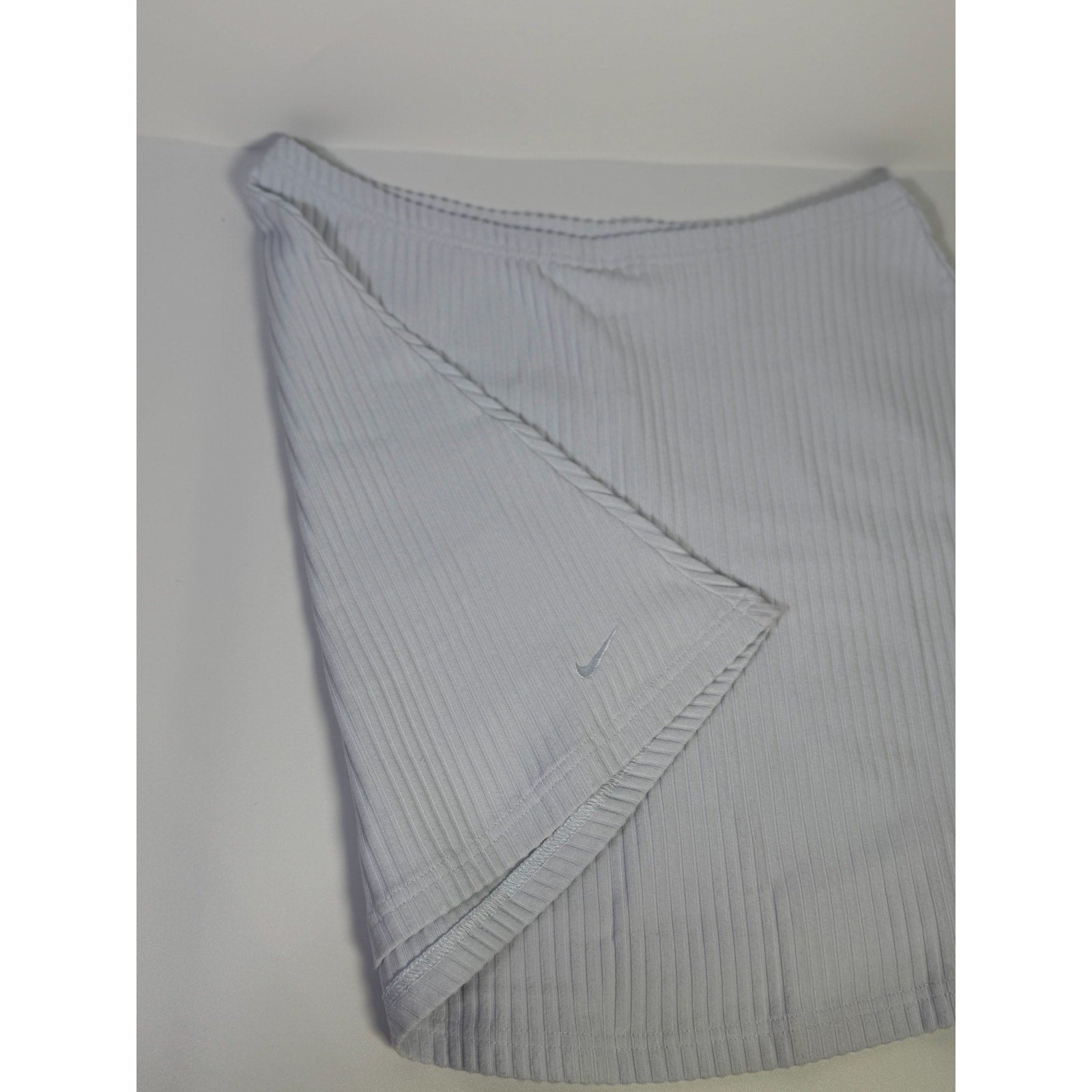 Nike women's ribbed mini skirt in sapphire mist, size M, featuring a fitted design and soft ribbed fabric.