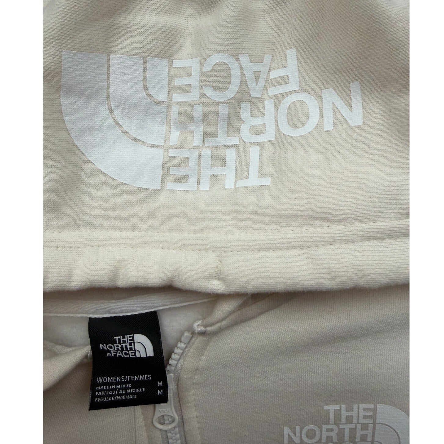 The North Face women's full-zip hoodie in Gardenia White, showing the soft fabric, hood, and front zipper detail.