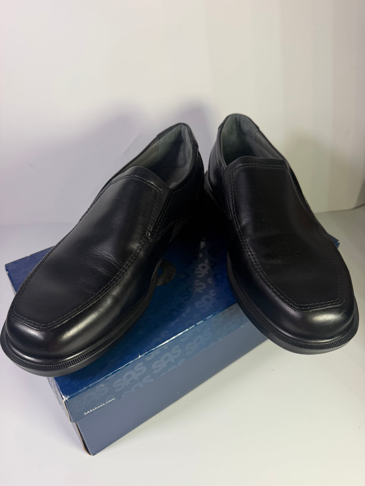 Black leather SAS men's slip-on loafers in size 11.5 W, featuring a sleek design and comfortable fit, new in box.