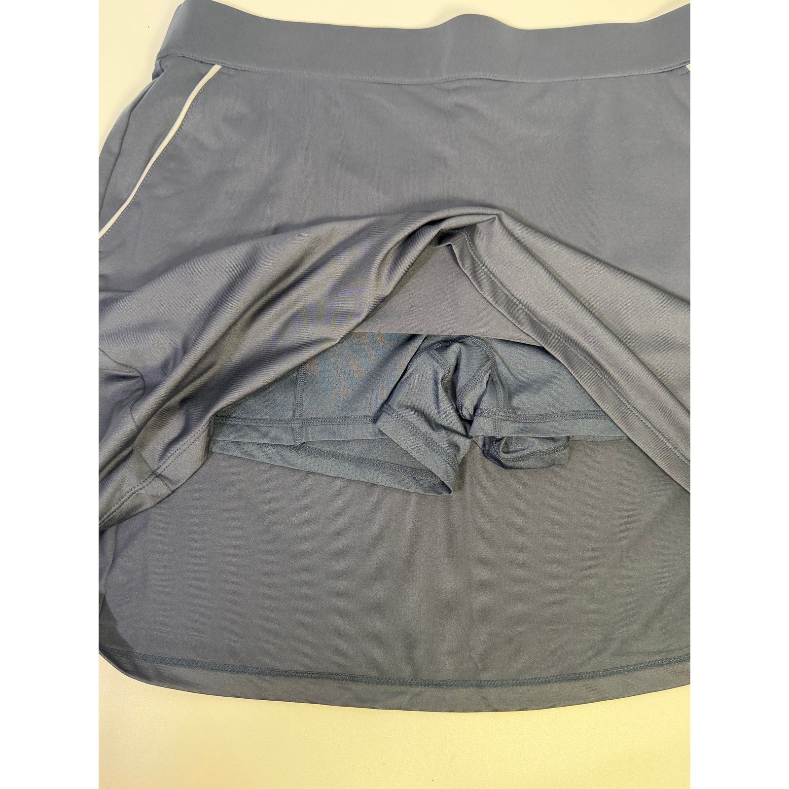 Dunning women's navy golf skort with built-in shorts, athletic skirt style, size large, featuring pleated design and functional pockets.