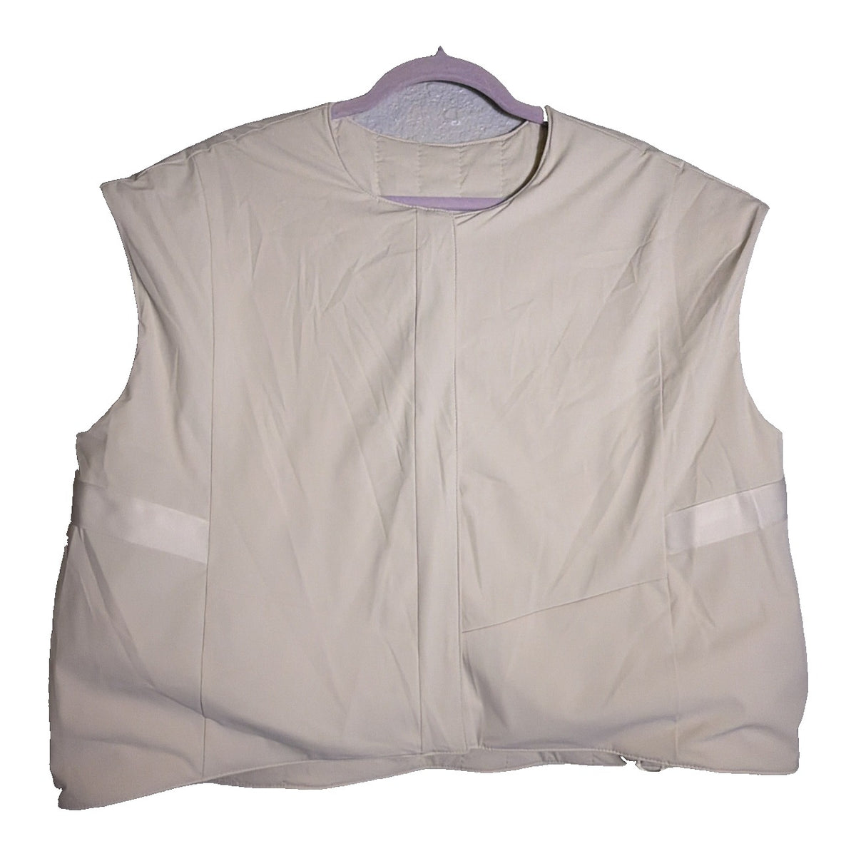 Nike 24.7 reversible quilted puffer vest for women in sail and cream, displayed on a hanger with a quilted pattern.