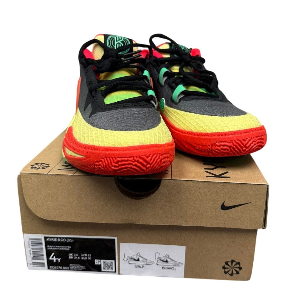 Nike Kyrie 8 GO basketball shoes in black and lemon chiffon for grade school, featuring a sleek design and Nike branding.