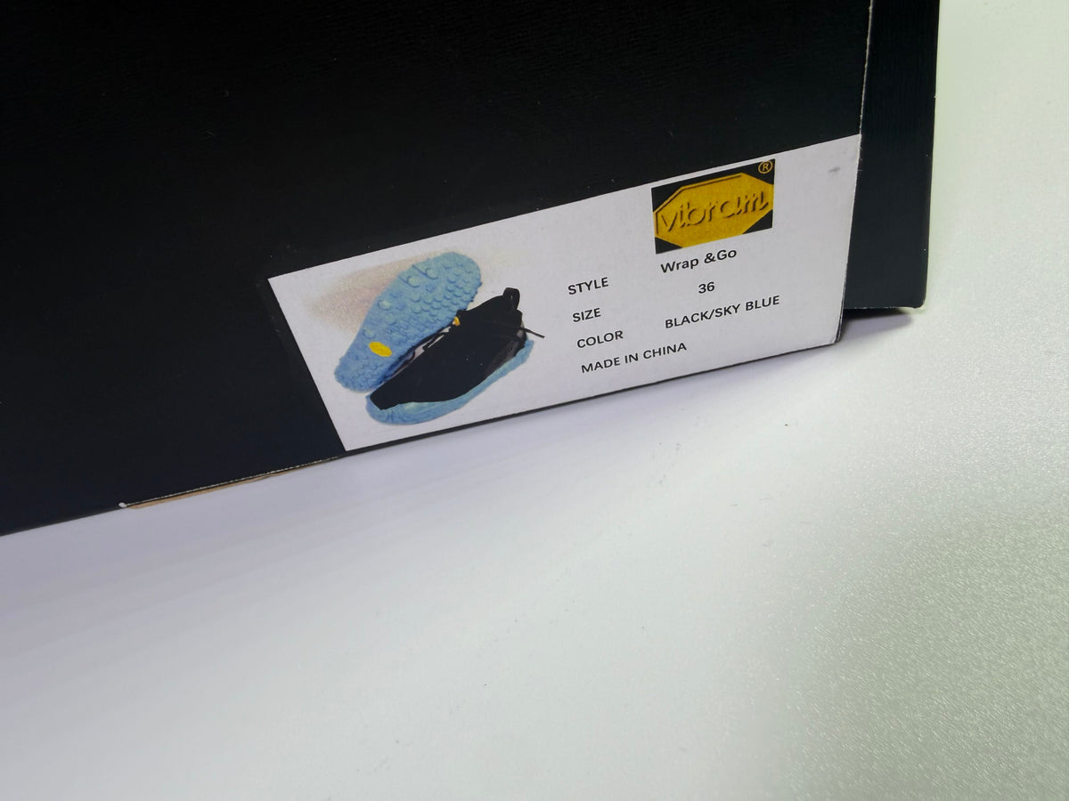 Vibram Wrap & Go athletic sneakers in black and sky blue, US size 6, featuring breathable mesh and flexible design.