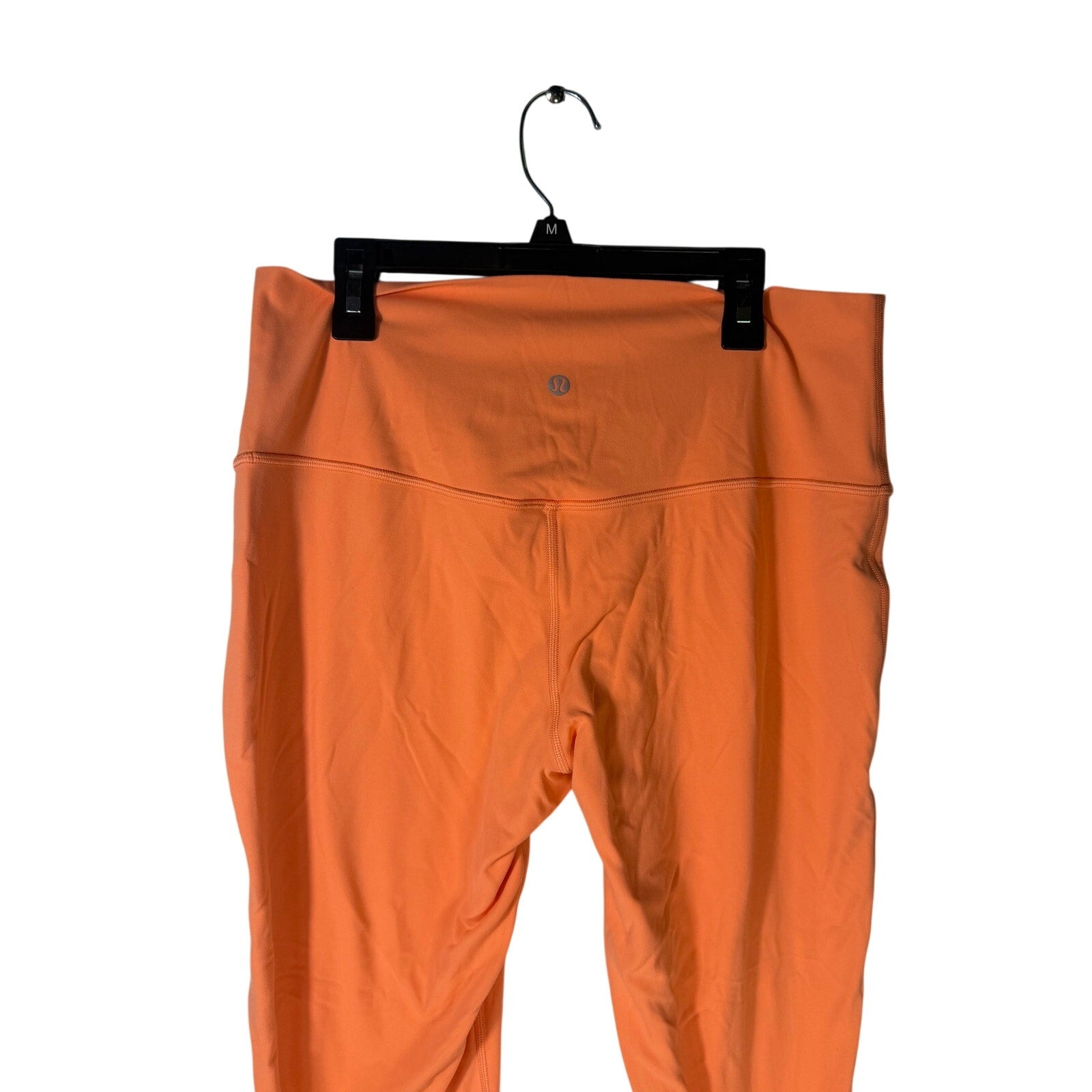 Lululemon women's high-rise burnt orange leggings in size 12, close-up of stretchy fabric and waistband detail
