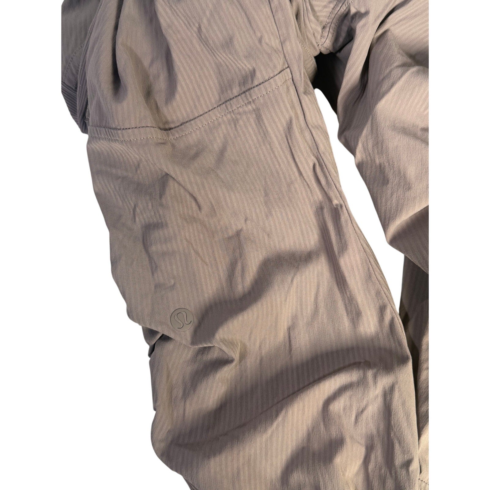 Lululemon women’s high-rise taupe gray tapered pants with ruched details, size 4, preowned, shown on a model.