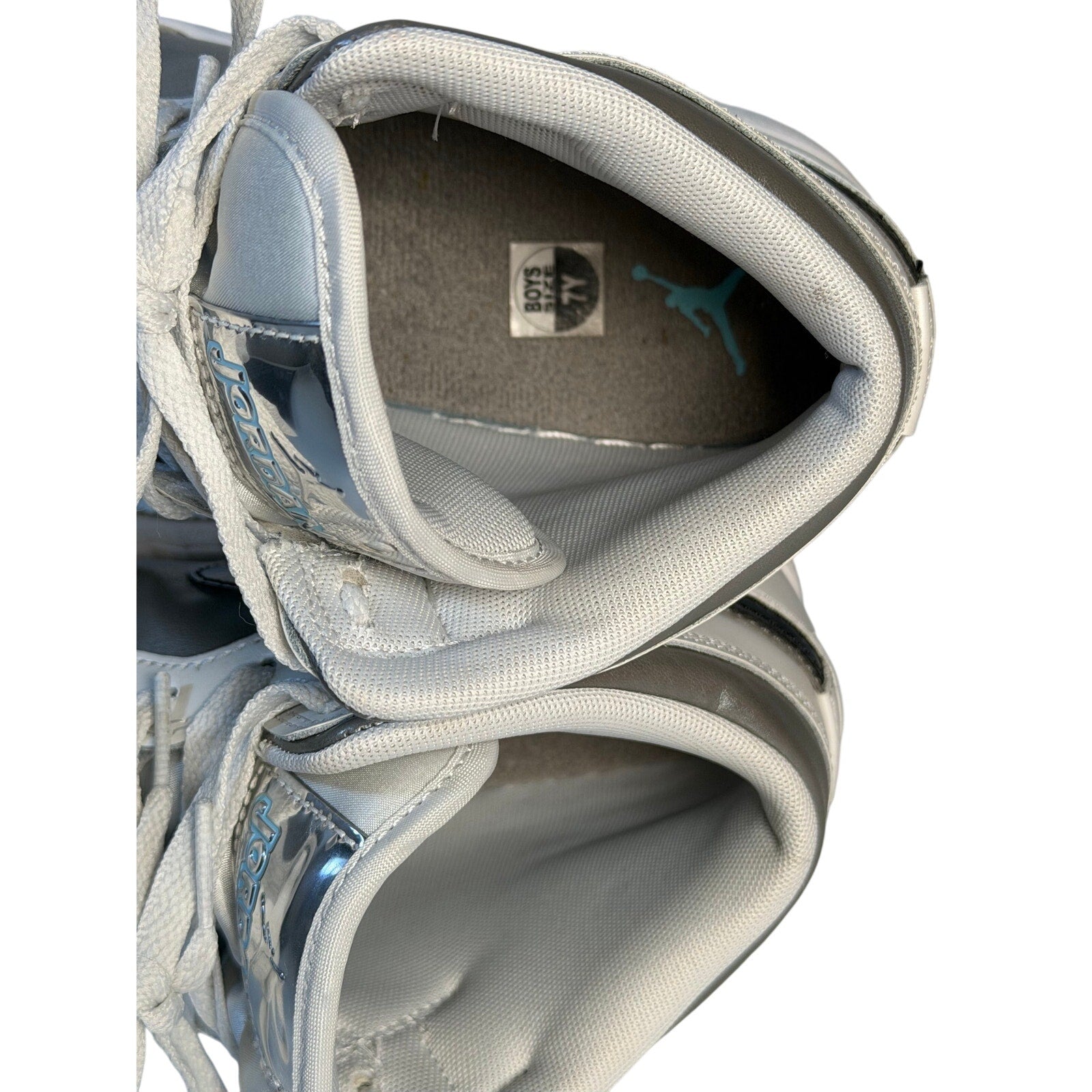 White, gray, and black Air Jordan 1 Mid GS sneakers for youth size 7Y, featuring classic Nike Air Jordan design