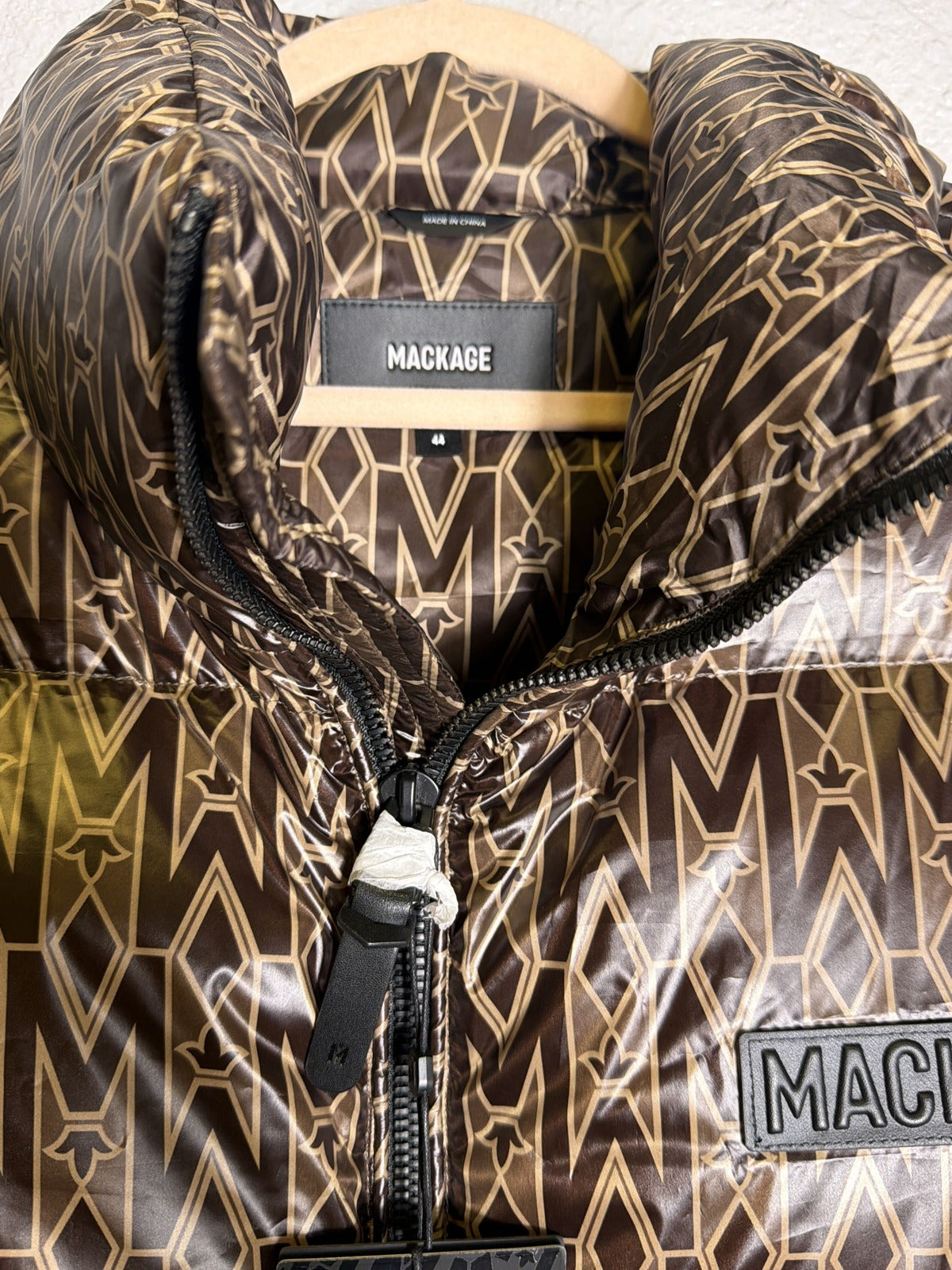 Mackage Kane-MG monogram down puffer vest in coffee brown, men's size XL, displayed on a hanger.