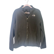 The North Face women's black full-zip fleece jacket with outdoor logo, featuring a stand-up collar and zippered pockets.