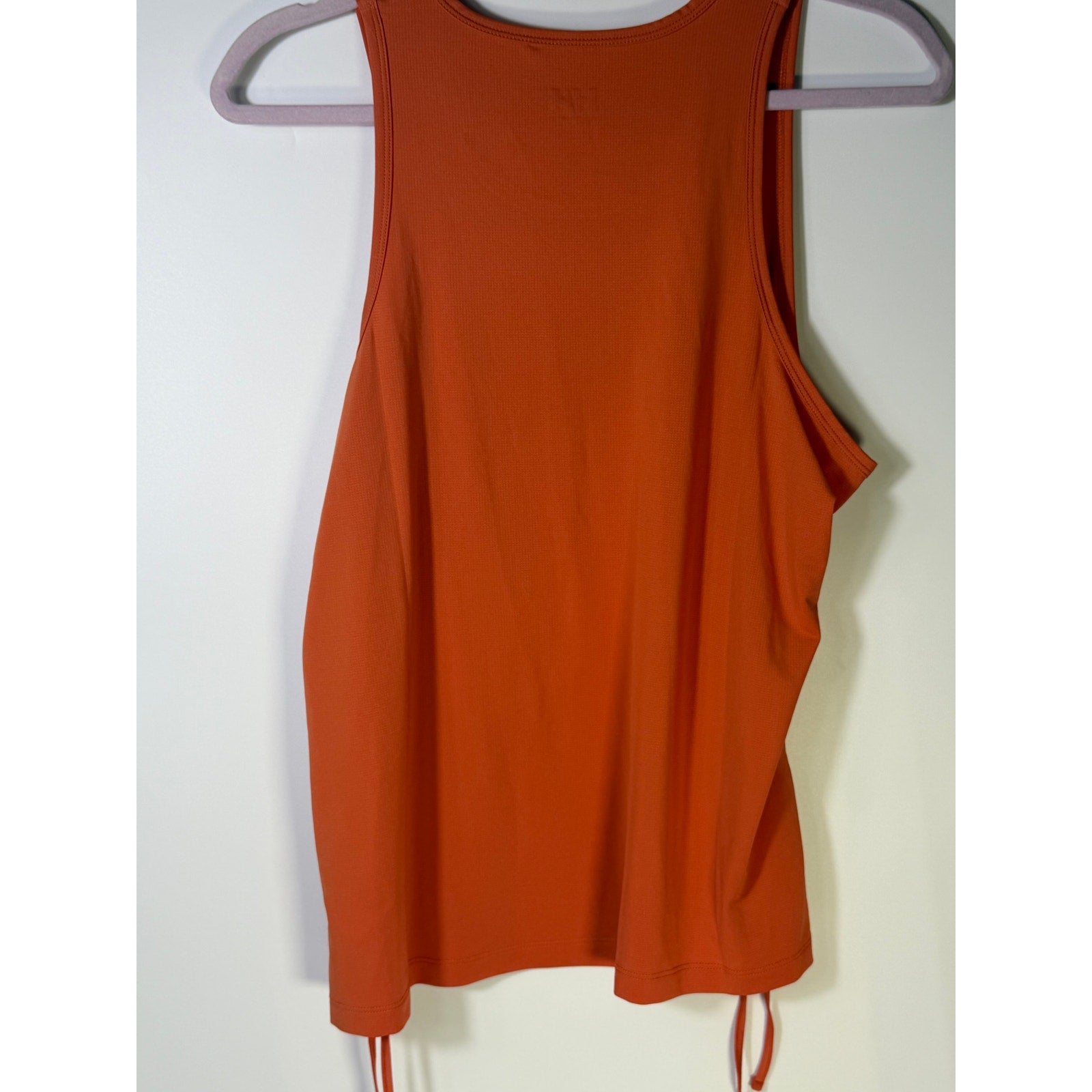 Helly Hansen women's orange active tank top with sleeveless design and drawstring hem, suitable as a sporty sports bra, size XL.