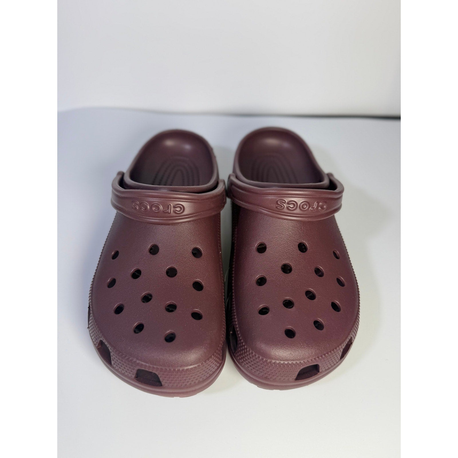 Burgundy Crocs Classic Clogs unisex slip-on comfort sneakers in size M10/W12, featuring a casual design and durable material.
