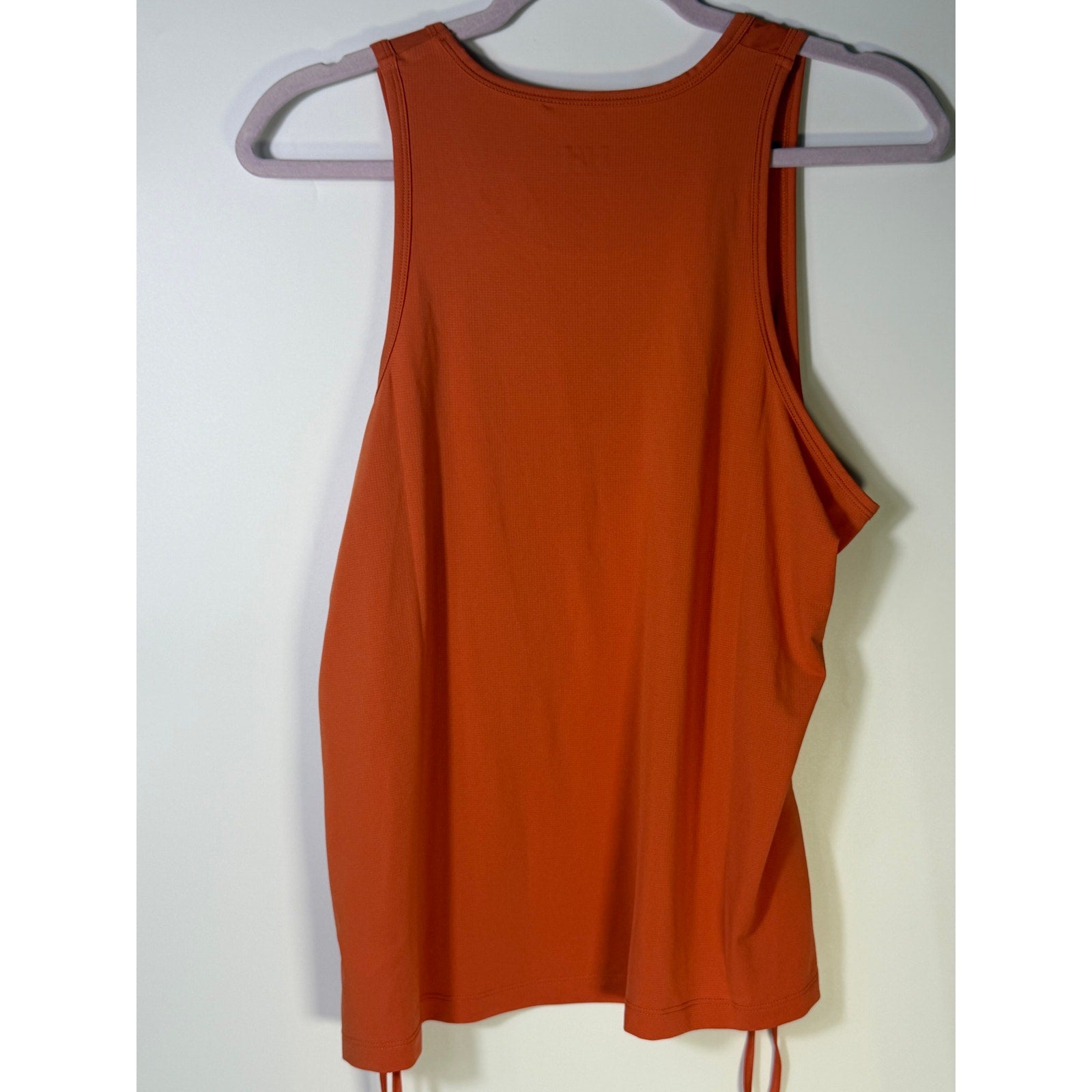 Helly Hansen women's orange active tank top with sleeveless design and drawstring hem, ideal for sports and workout activities.