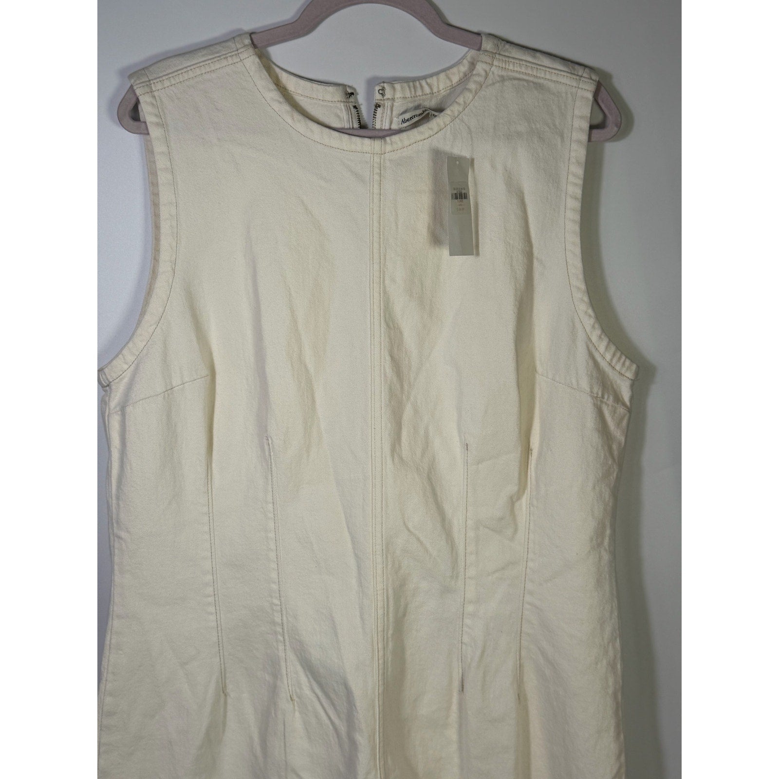 Abercrombie & Fitch cream denim mini shift dress in size XL, new with tags, displayed flat showing front view and sleeveless design.