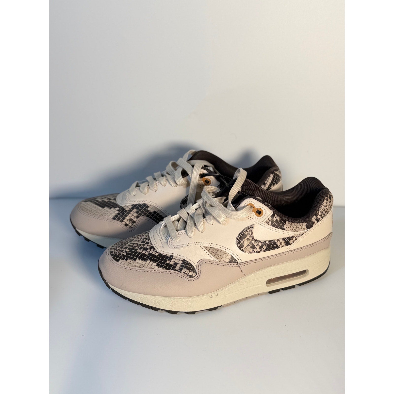 Nike Air Max 1 Premium Snakeskin sneakers in white and gray for women, showcasing the stylish snake pattern and sleek design.