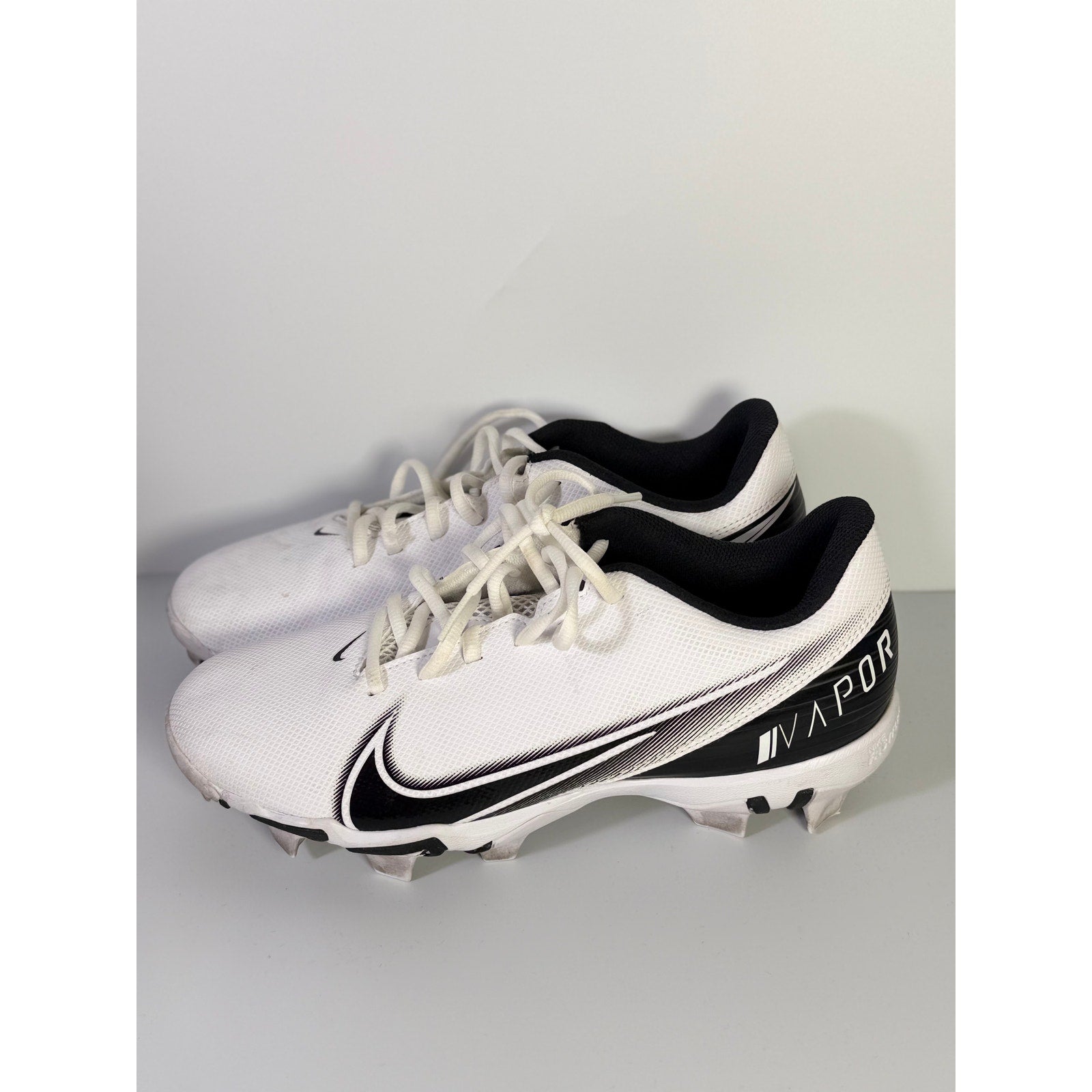Nike Vapor football cleats in white and black, men's size 8.5 US, showing the athletic footwear designed for football players.