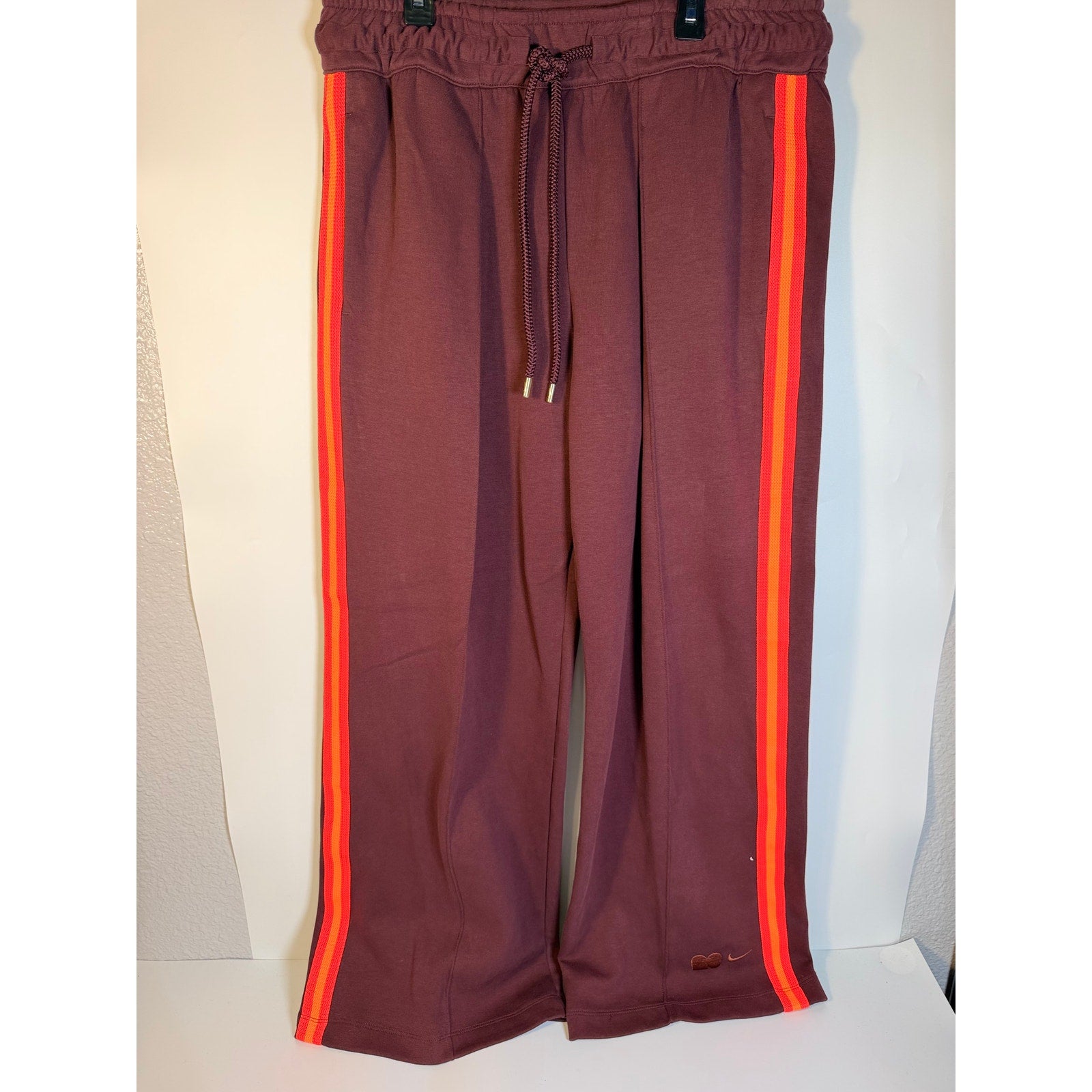 Nike NOCTA men's brown and orange striped fleece track pants with open hem design, size large.