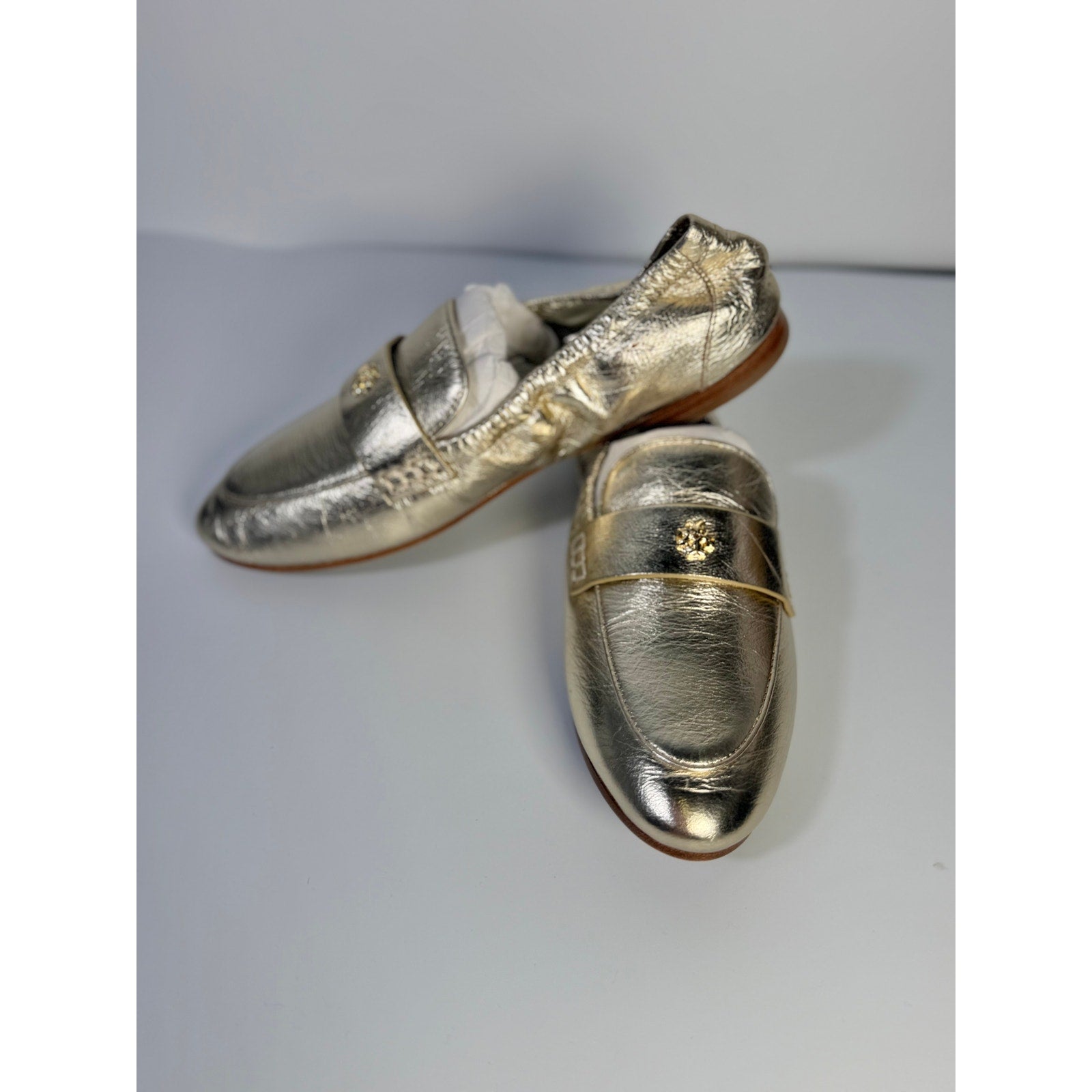 Tory Burch women's gold metallic leather loafer flats with slip-on design, size 5M, featuring a sleek, stylish look.