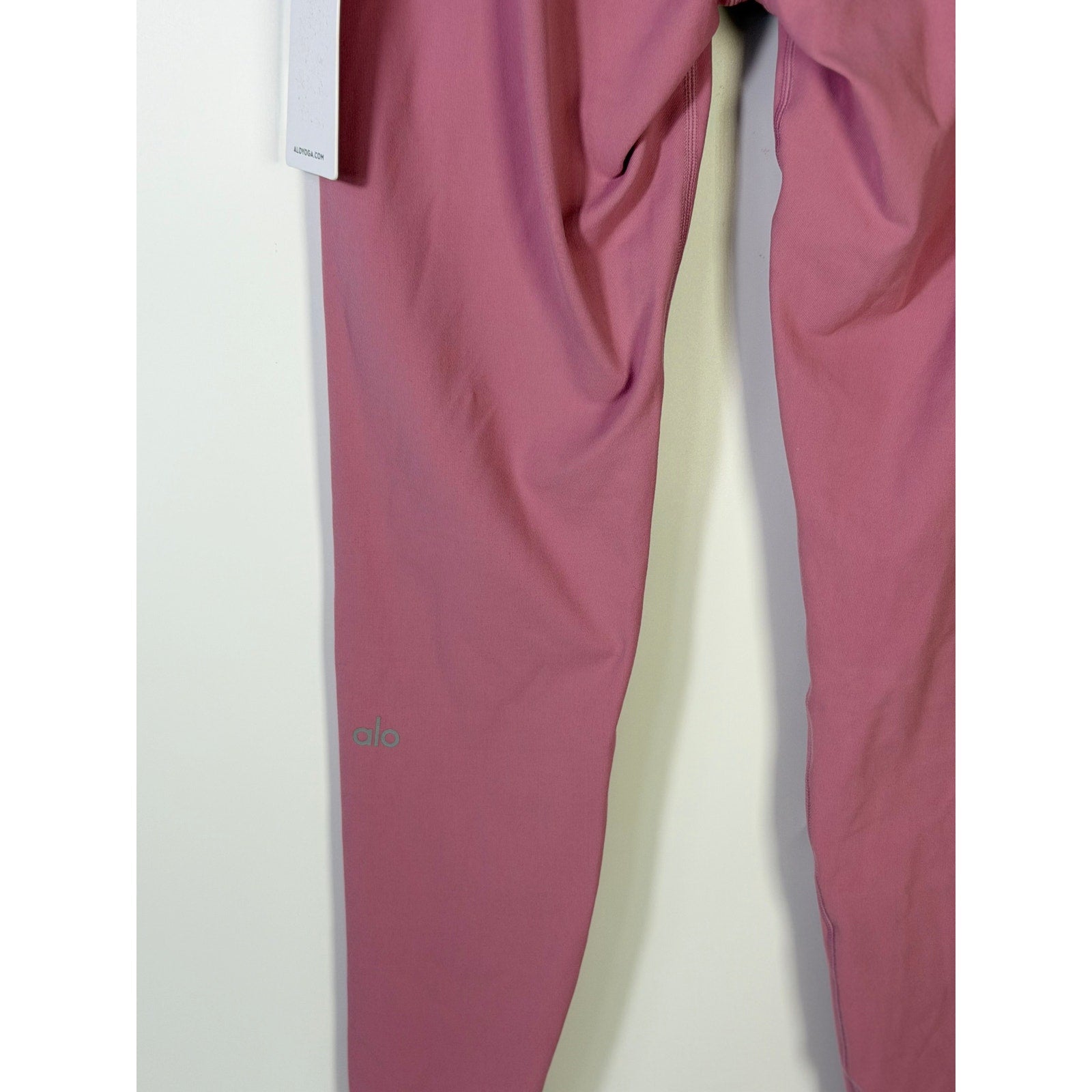 Alo Yoga 7/8 high-waist airbrush leggings in pink Wild Rose, women's size L, showing the form-fitting, stretchy fabric.