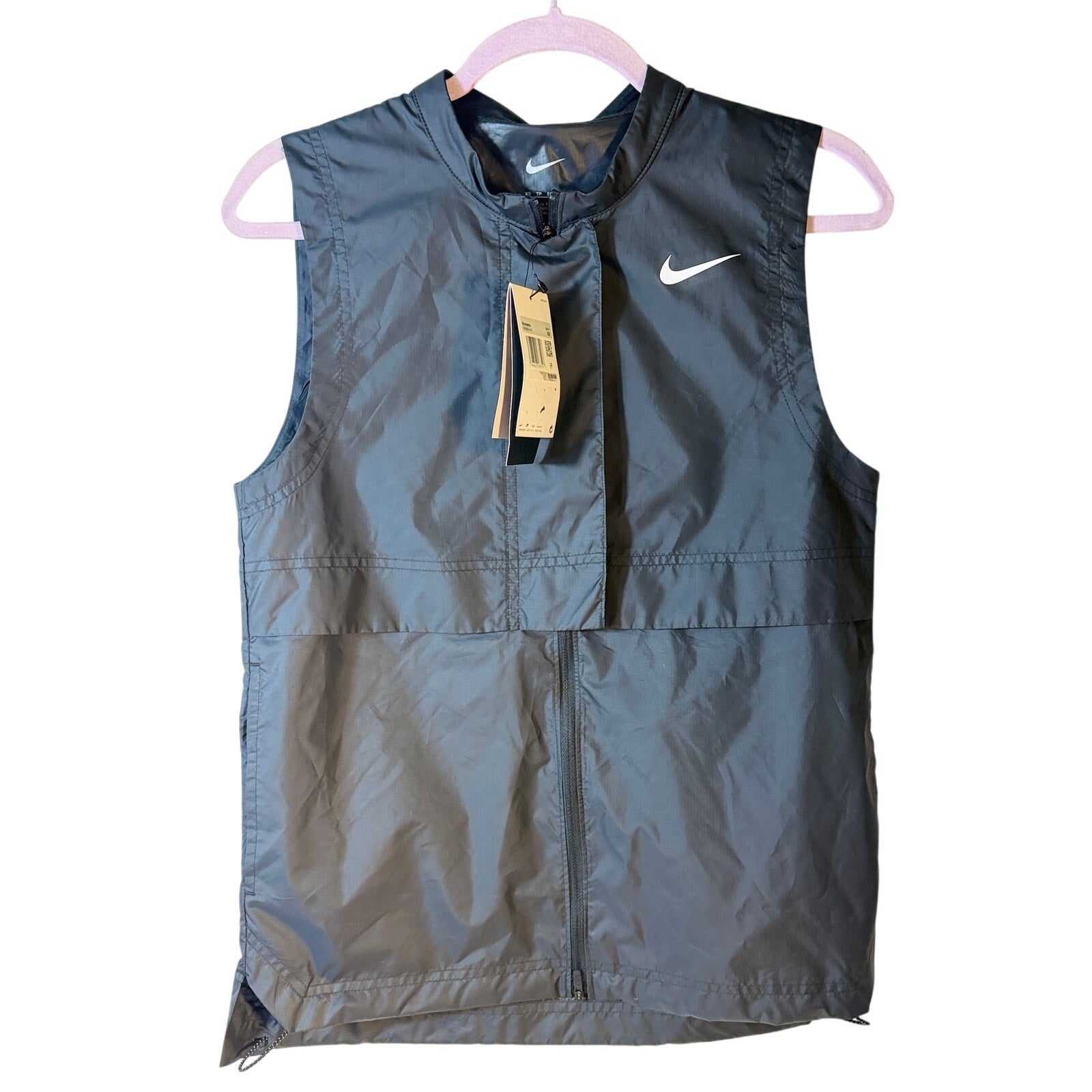 Nike Golf Women's gray Storm-FIT sleeveless full-zip vest, XS size, lightweight athletic outerwear with stand collar and zip pockets.