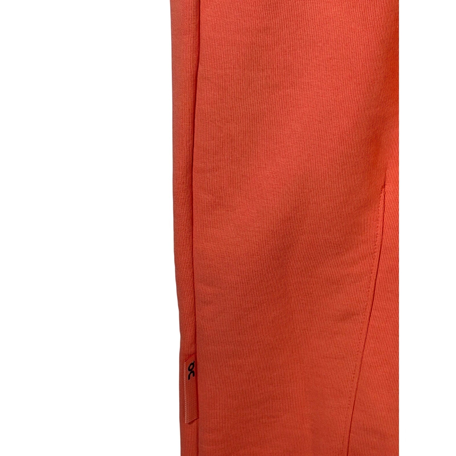 On Running women's coral orange ribbed jogger sweatpants, size XL, showing the relaxed fit and ribbed waistband.