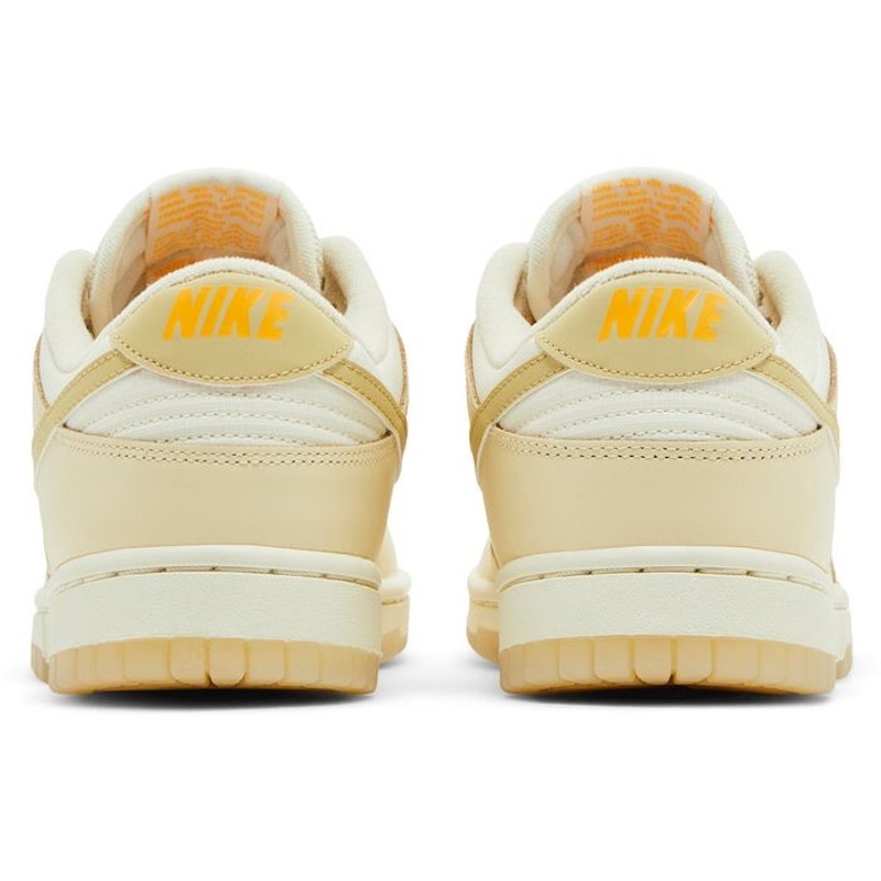 Nike Dunk Low women's sneakers in gold and white, size 6.5, featuring a classic low-top design and Nike branding.