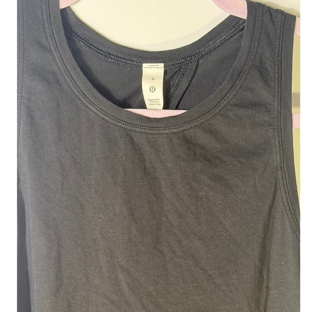 Lululemon women's black high-neck open-back athletic tank top, size 4, showing front and back details.