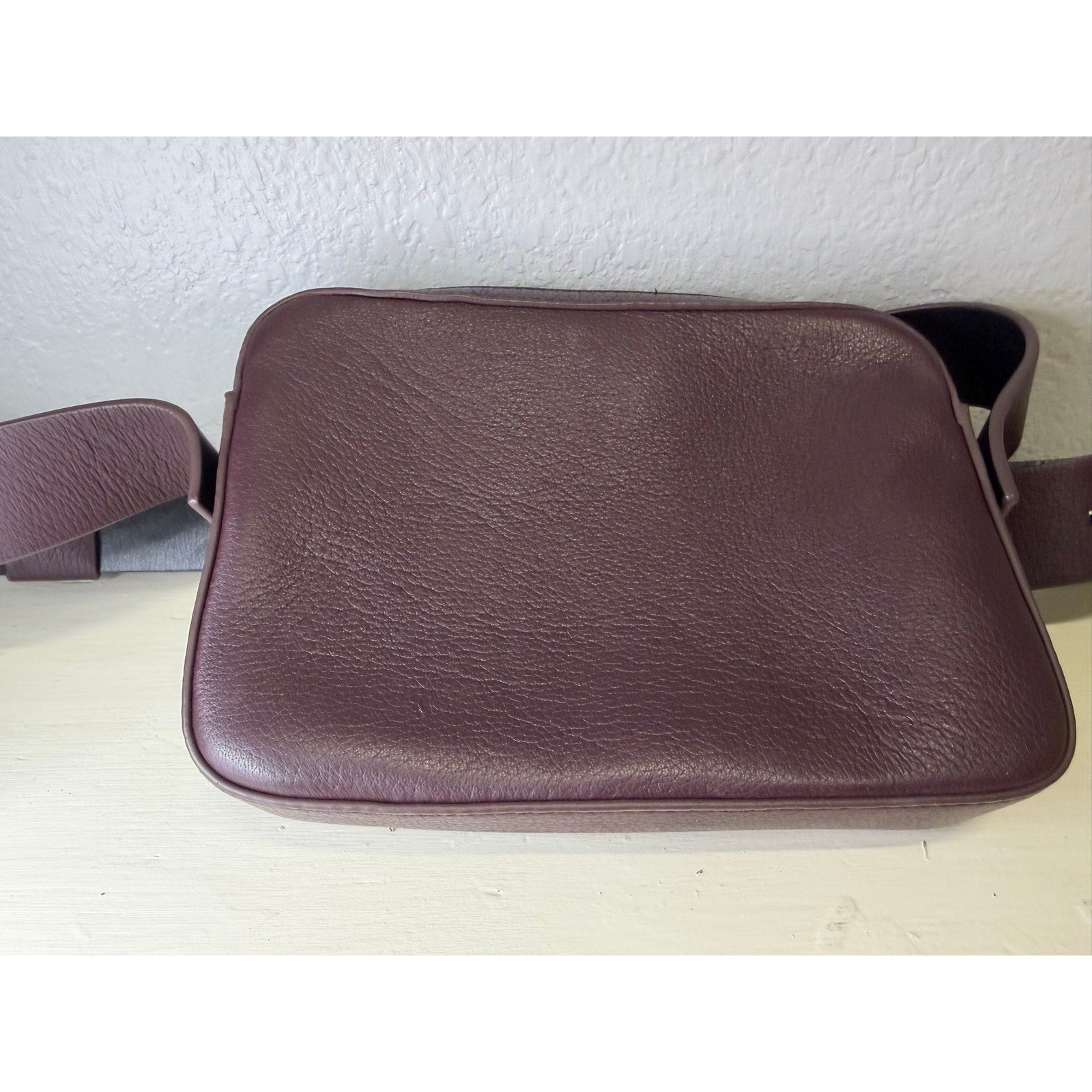 AllSaints women's burgundy pebbled leather crossbody handbag with adjustable strap and camera bag style.