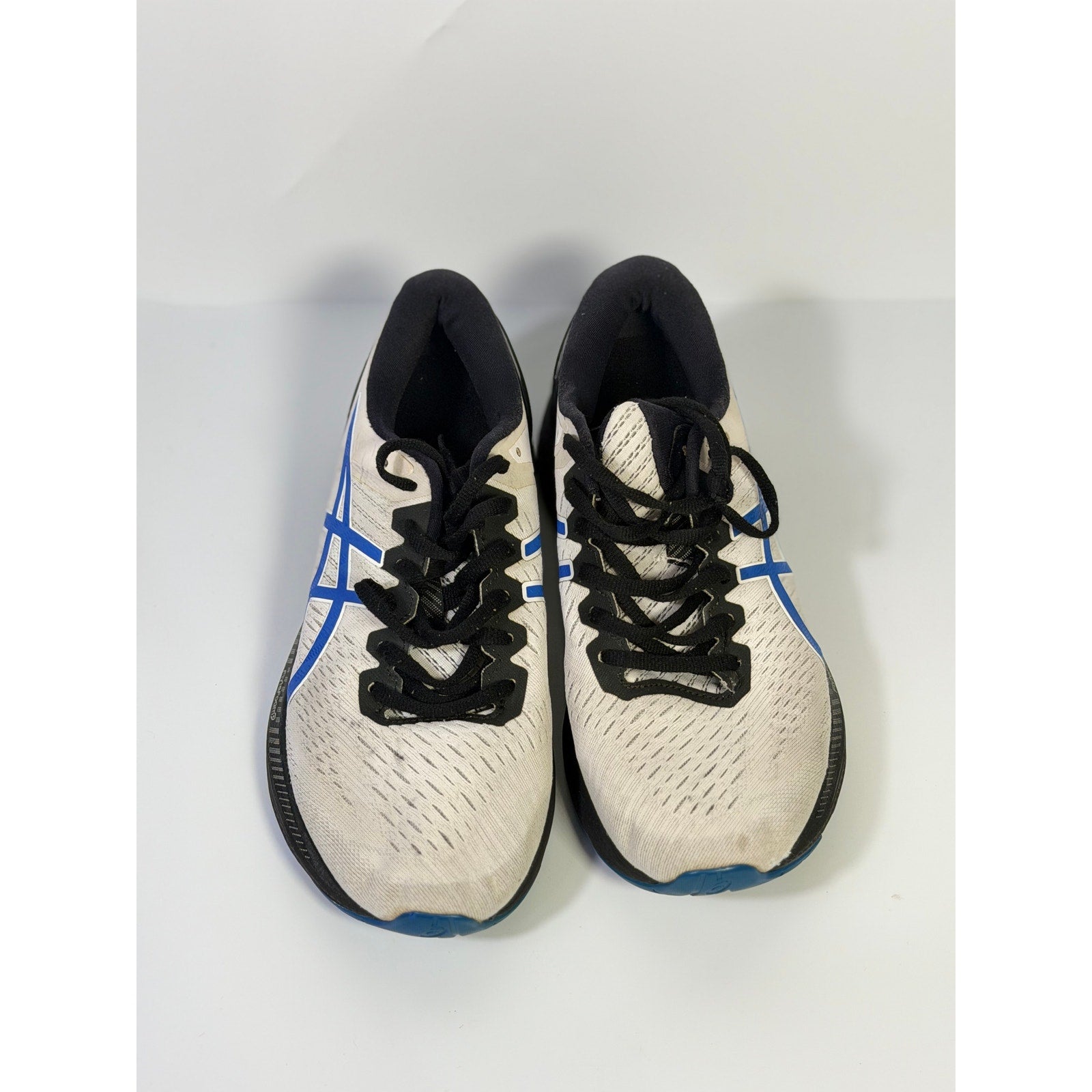 Men's ASICS Gel Cumulus 24 running sneakers in white, blue, and black, featuring cushioned athletic design and breathable mesh.