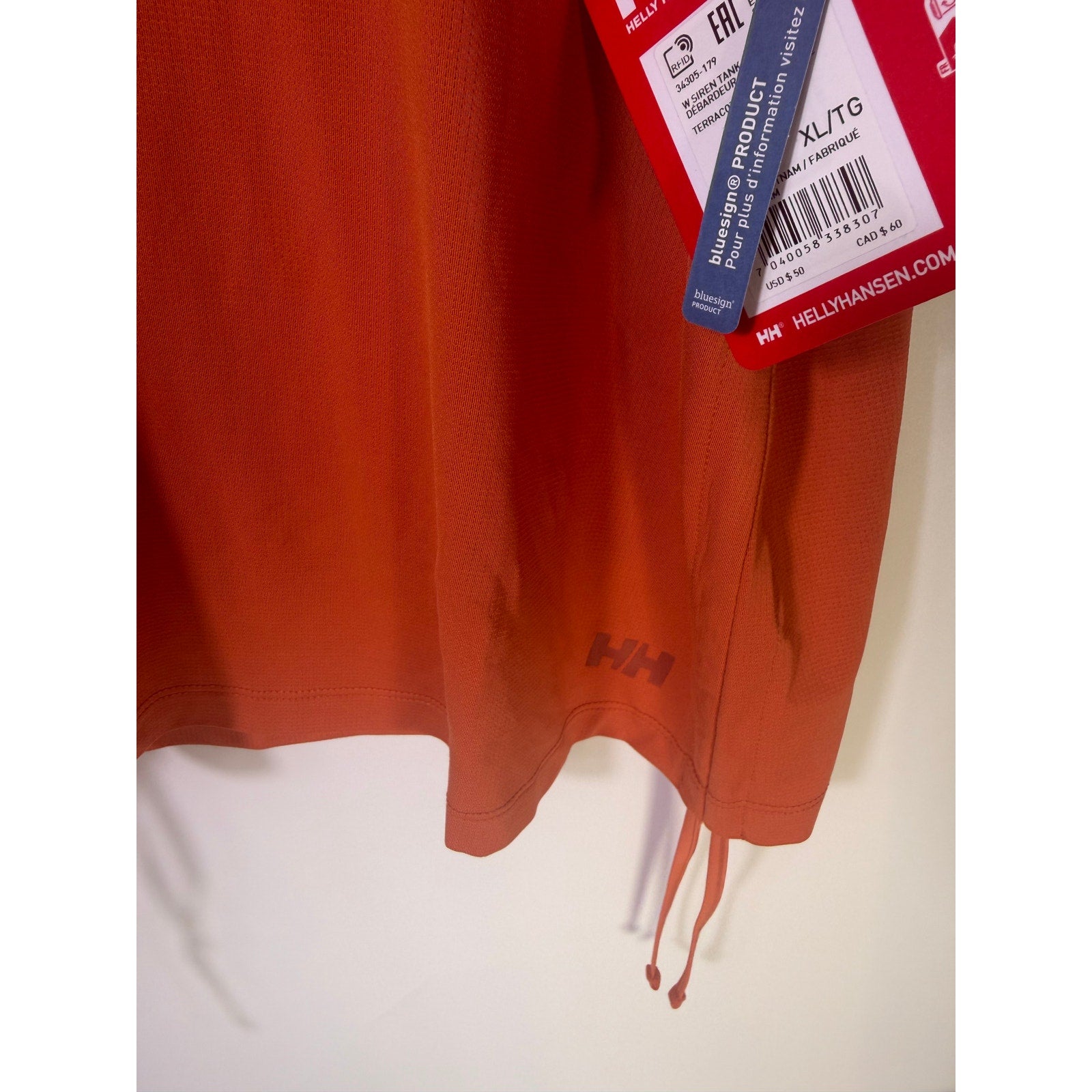Helly Hansen women's orange active tank top with sleeveless design and drawstring hem, ideal for sports and exercise.