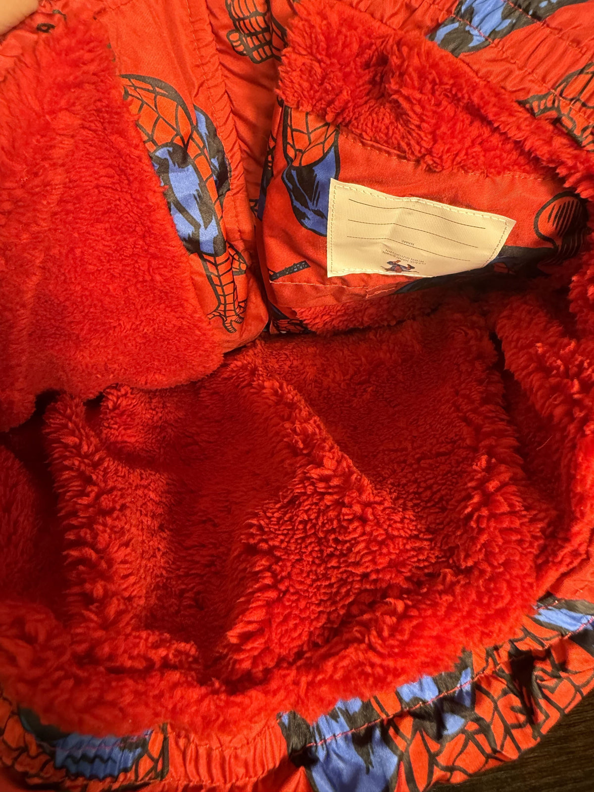 Marvel Spider-Man hooded puffer jacket for boys size 6/7, red with sherpa lining, featuring Spider-Man graphic and quilted design.