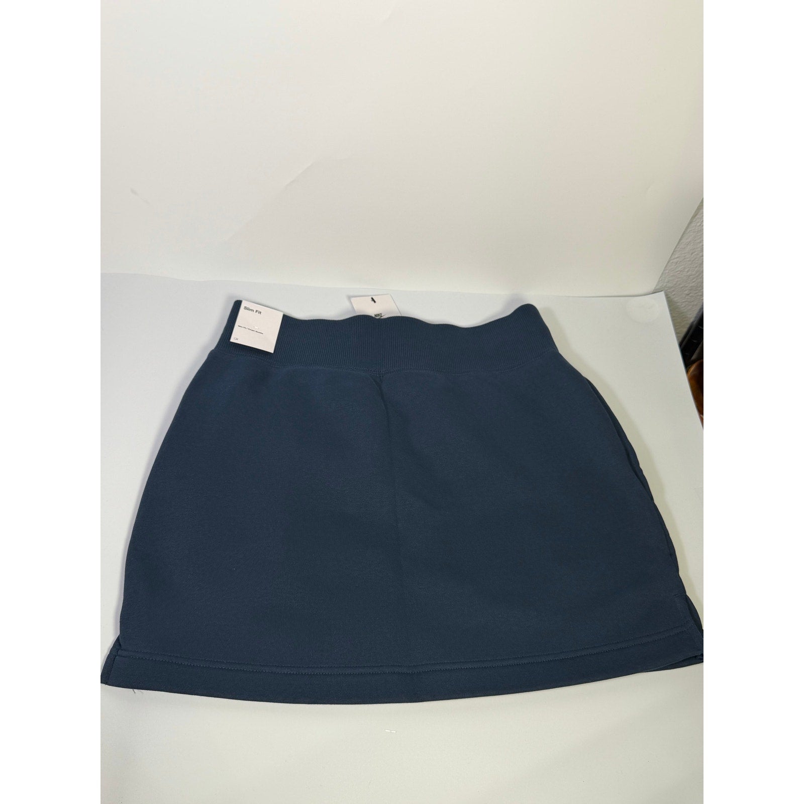Nike women's navy blue fleece drawstring mini skirt, size M, front view showing soft fabric and adjustable waistband.