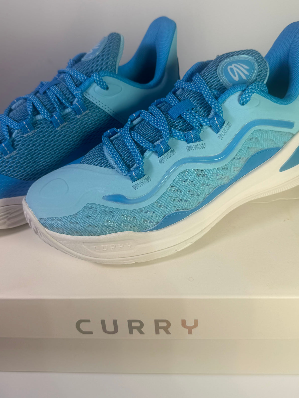 Under Armour Curry Flow basketball shoes in blue for youth size 7Y, featuring a sleek design and athletic sole.
