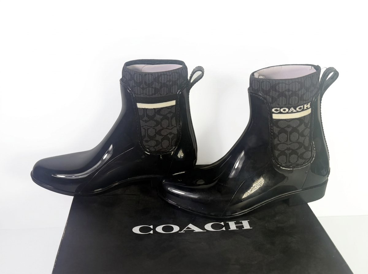 Coach women's black Signature Jacquard knit Chelsea rain bootie, size 7B, with box, showcasing stylish waterproof footwear.