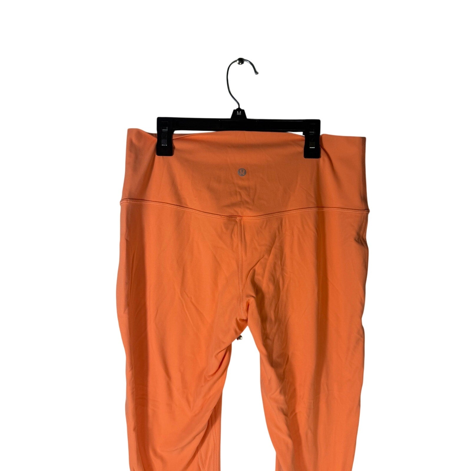 Lululemon women's high-rise leggings in burnt orange, size 12, snug fit with smooth fabric and elastic waistband.