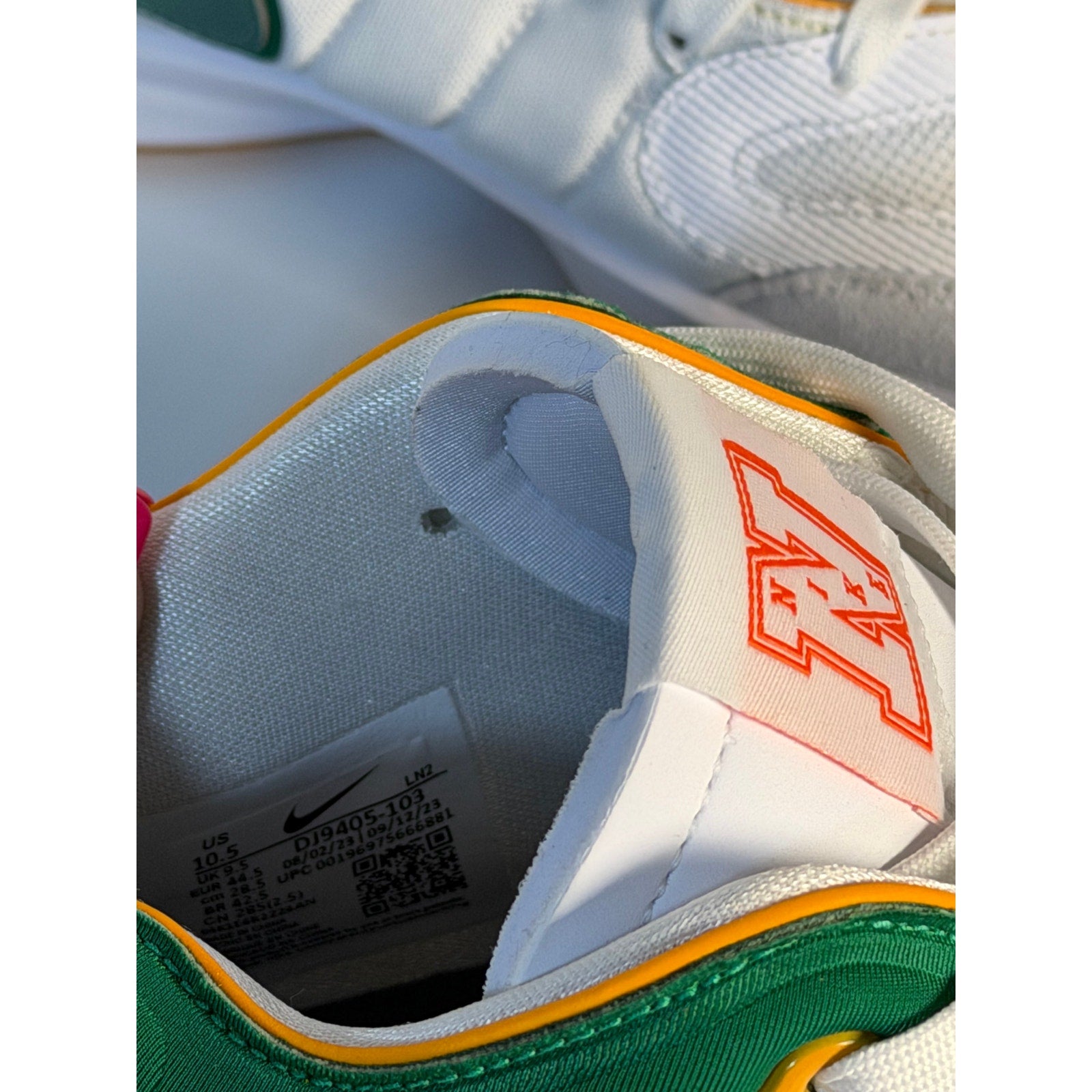 Nike men's athletic sneakers in white with green and orange accents, size 10.5, casual Nike sneakers for active wear.